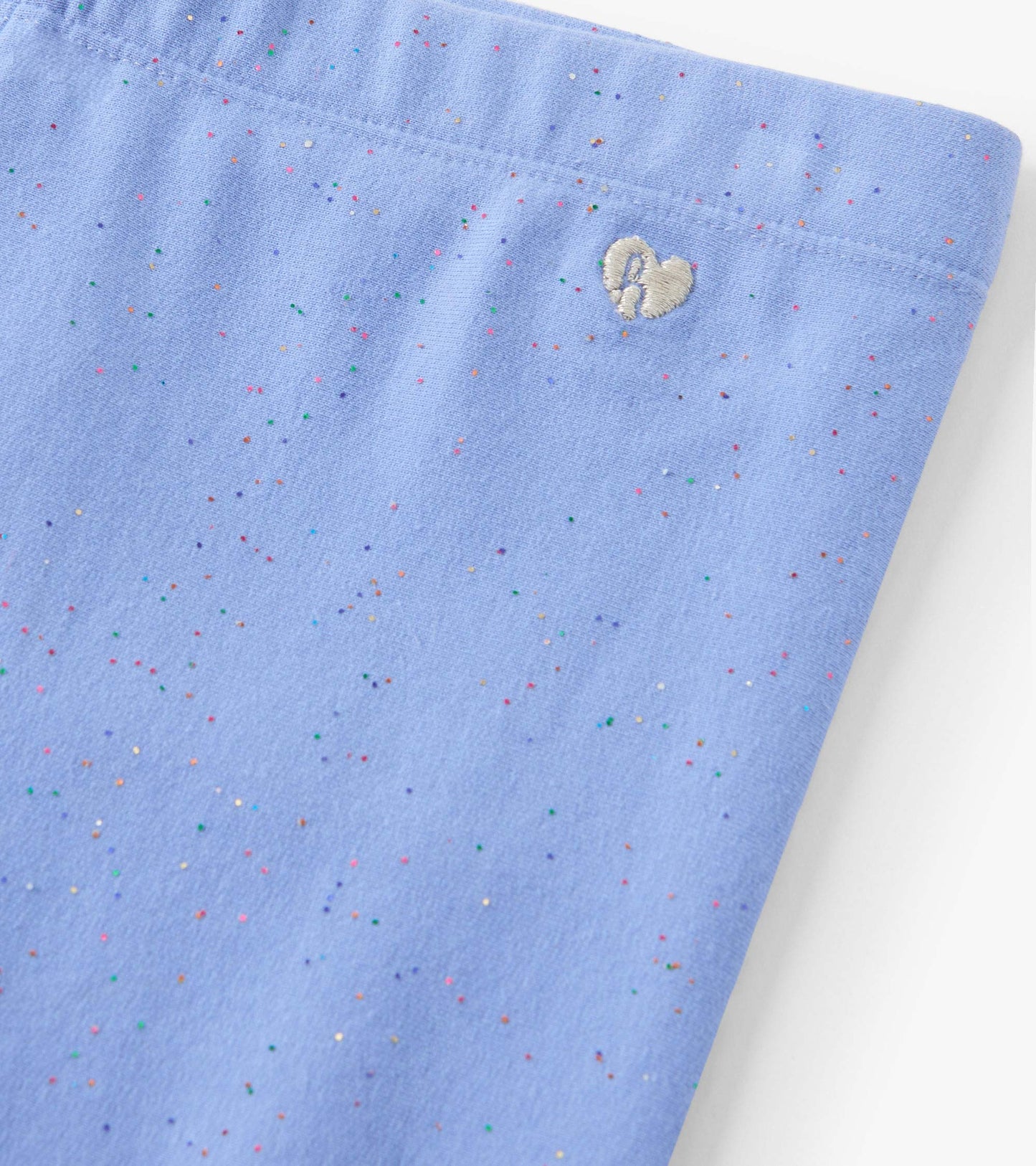 Cornflower blue cozy leggings with a soft texture and colorful speckles, featuring a small heart embroidery detail.