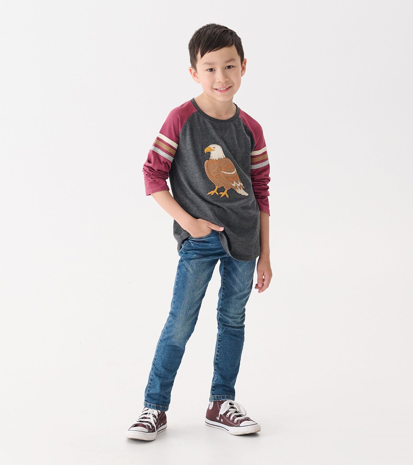 Classic blue jeans for boys, featuring a slim fit and casual style, paired with a graphic long-sleeve shirt.