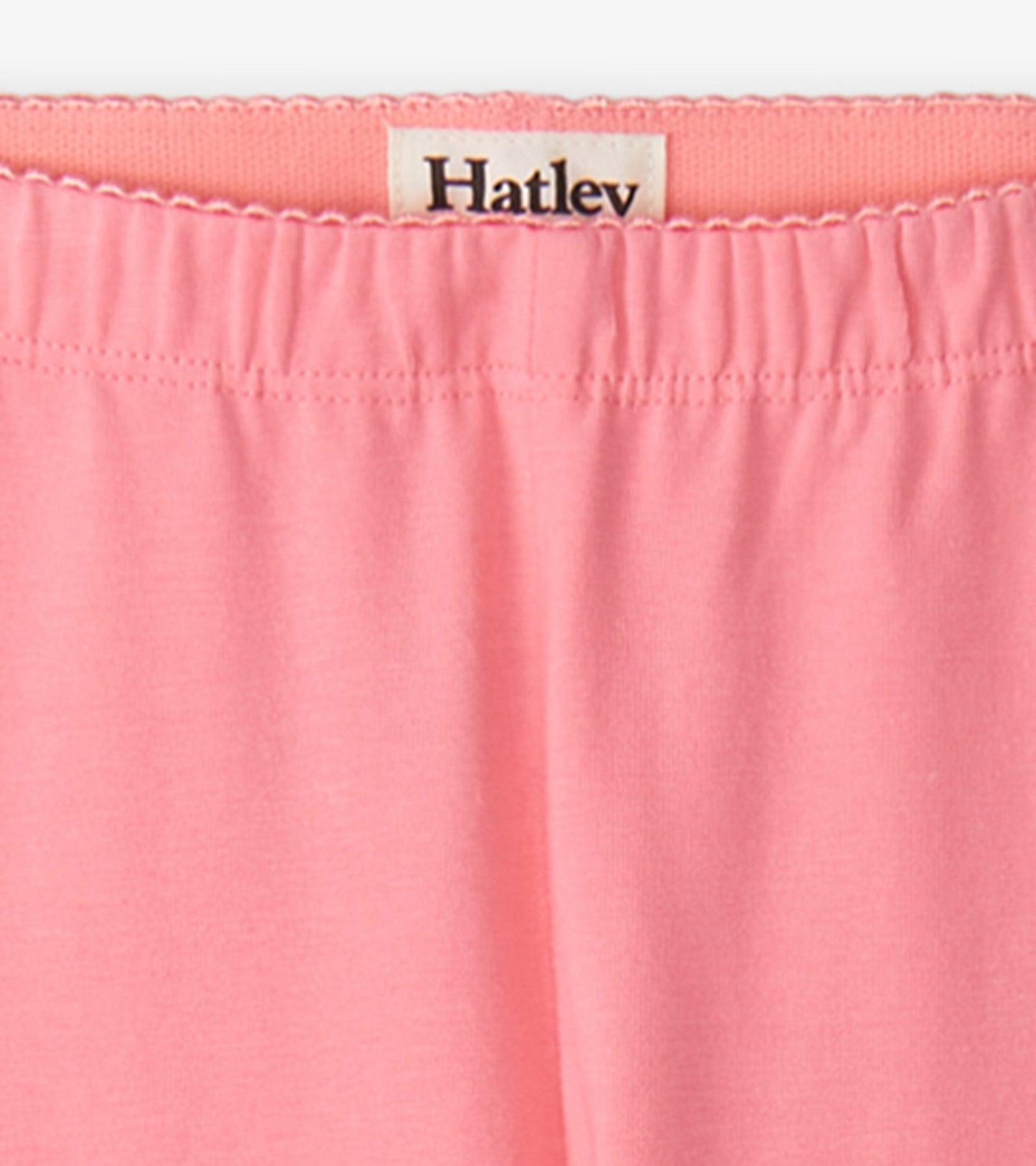 Light pink leggings with an elastic waistband, made from soft, stretchy material, suitable for active wear.