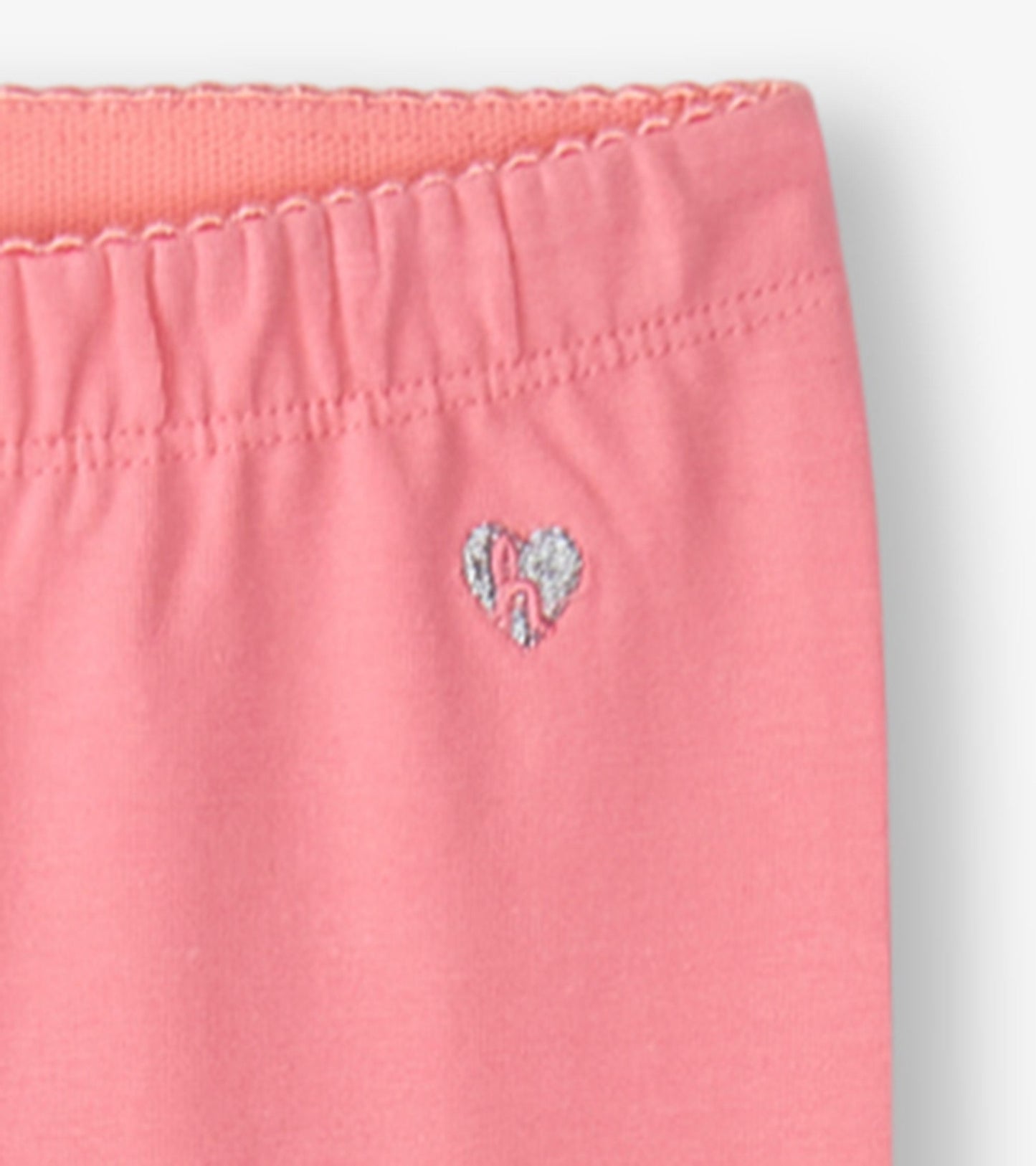 Pink leggings with an elastic waistband and a small heart embroidery detail.