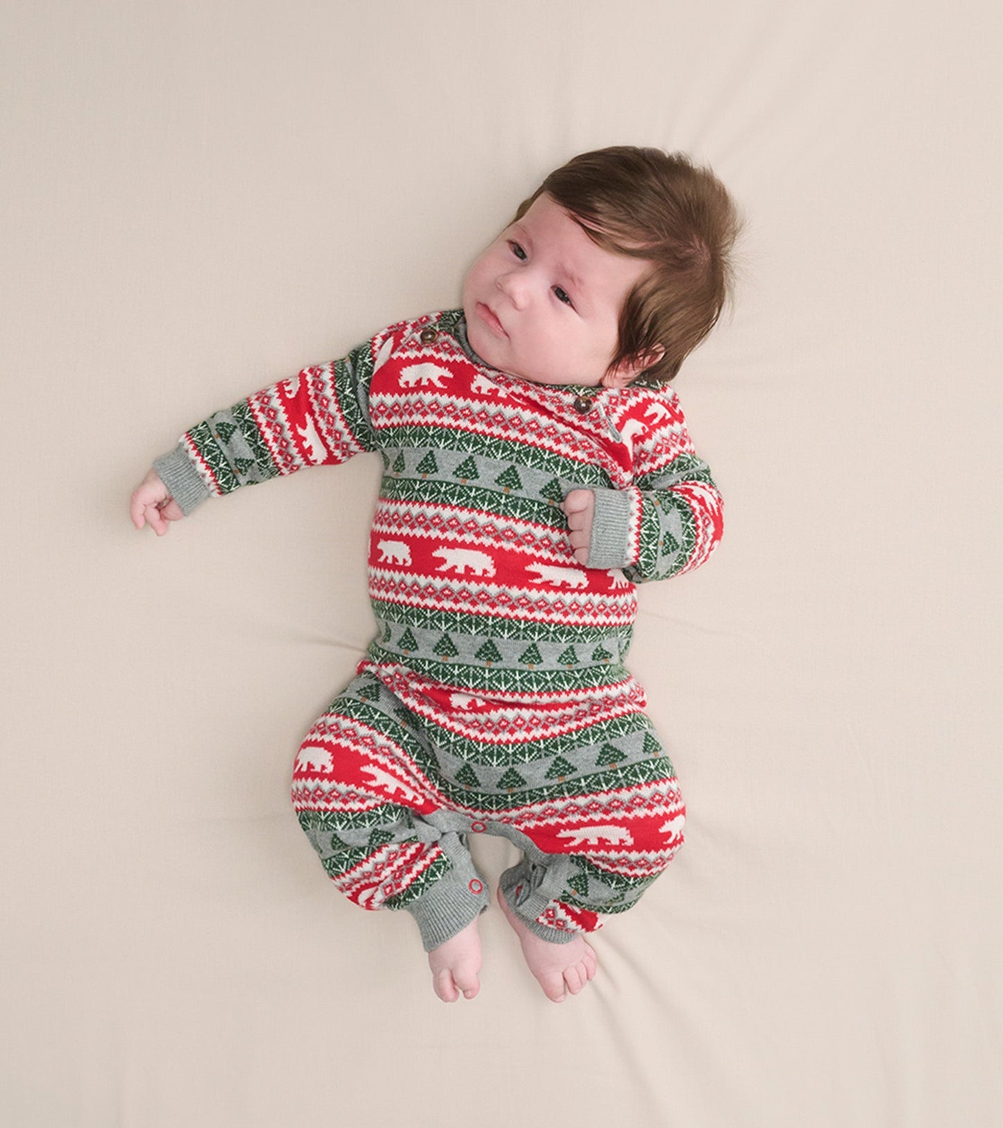 Red and green Fair Isle sweater romper featuring polar bear and tree patterns, suitable for infants.