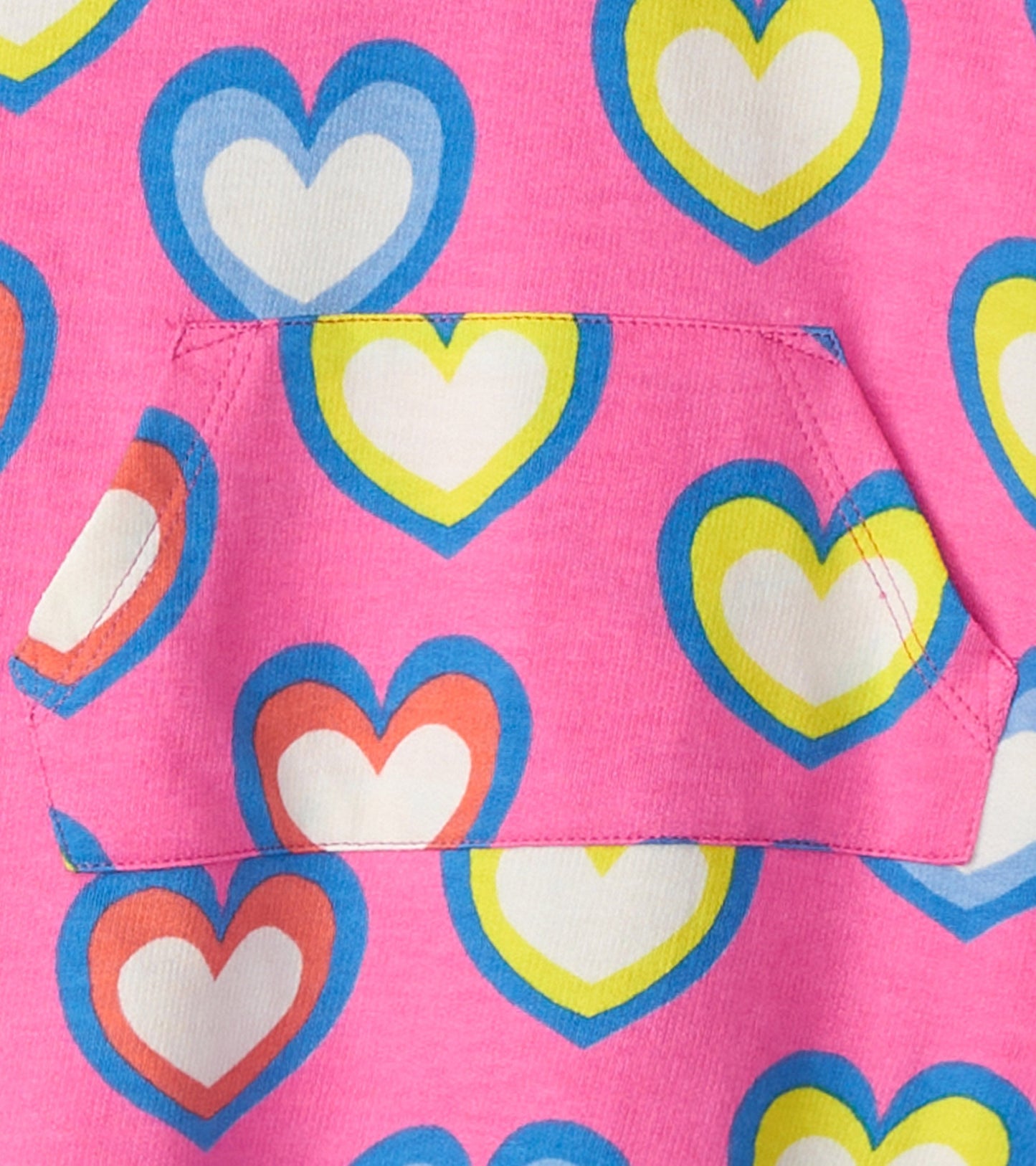 Pink terry dress featuring a colorful heart pattern in blue, yellow, and red, with a front pocket detail.
