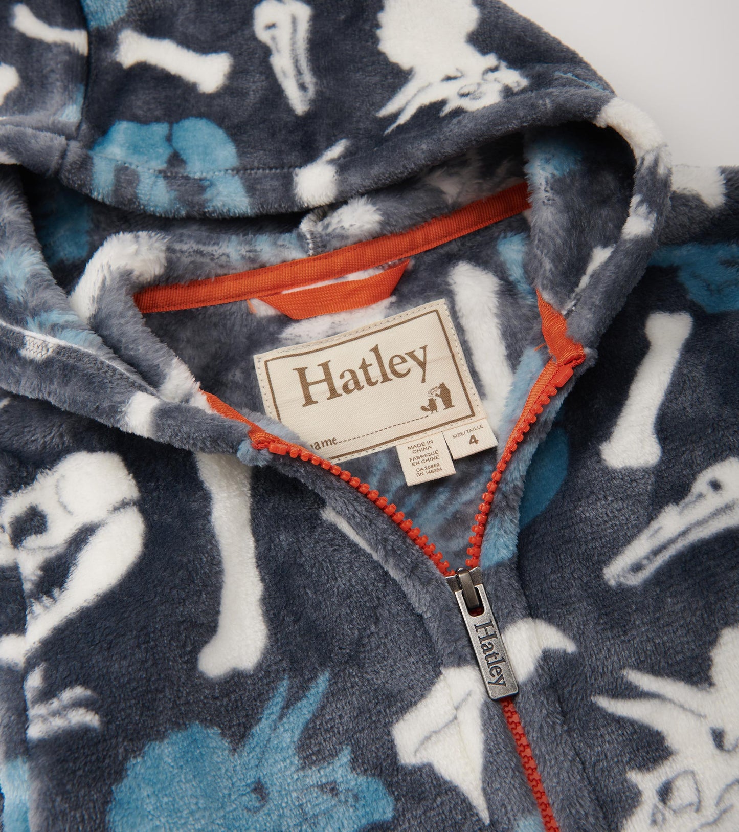 Fleece zip-up hoodie featuring a dinosaur fossil pattern in blue and white on a dark gray background.