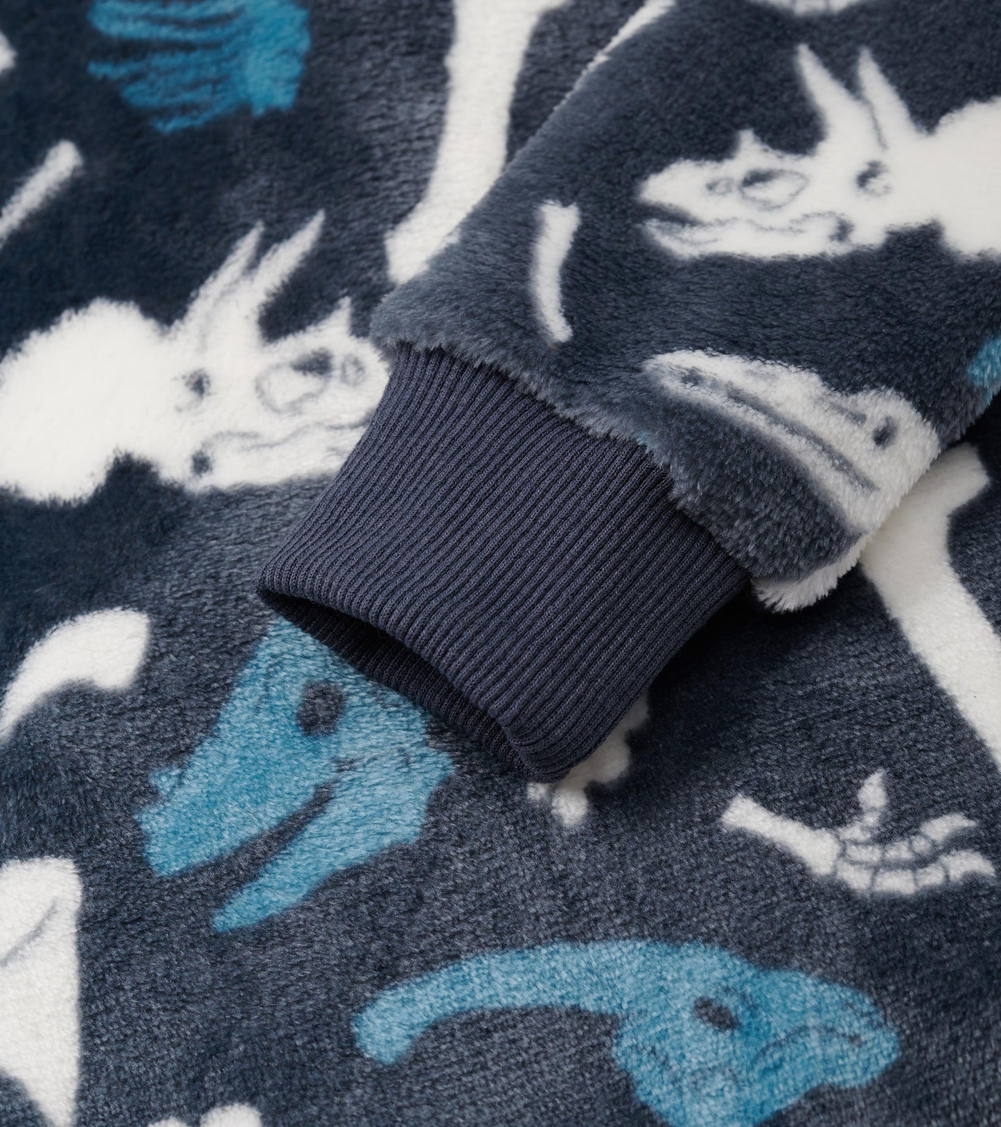 Navy fleece hoodie featuring dinosaur fossil patterns in white and blue, with a ribbed cuff detail.