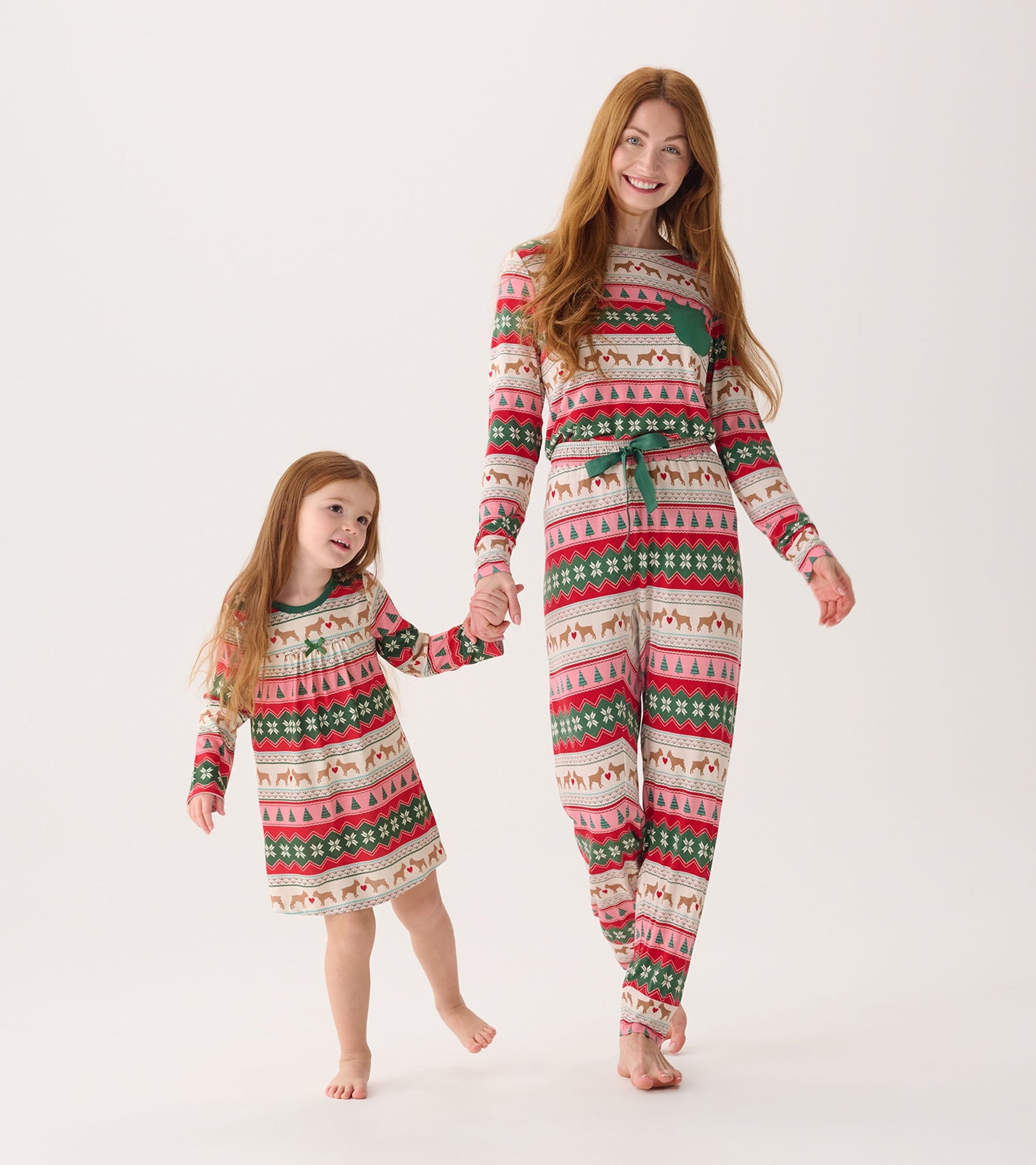 Bamboo pyjama set featuring a festive puppy hearts Fairisle pattern in red, green, and cream, worn by a mother and daughter.
