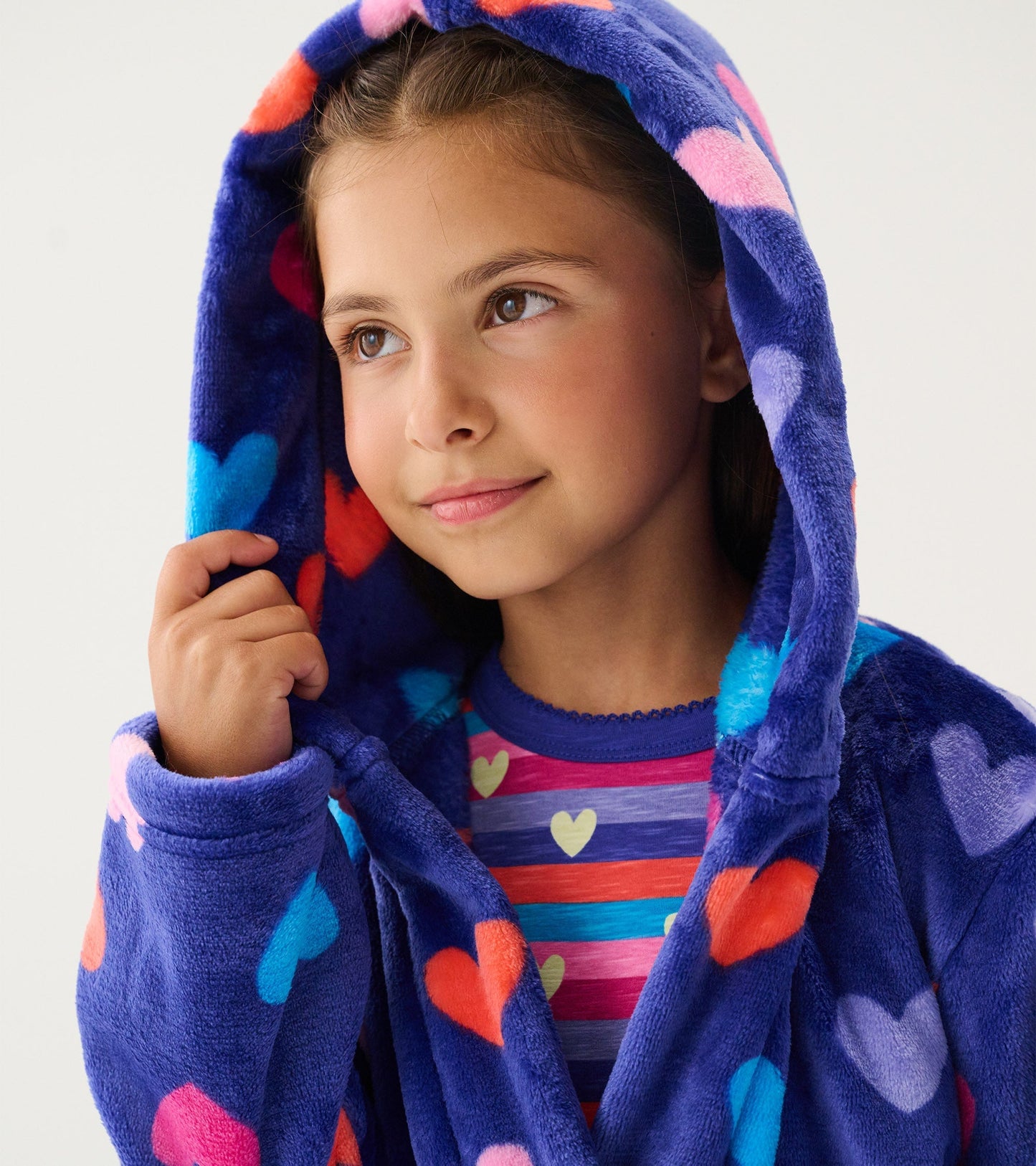 Purple fleece robe with colorful heart patterns, featuring a hood and a cozy design, worn by a young girl.