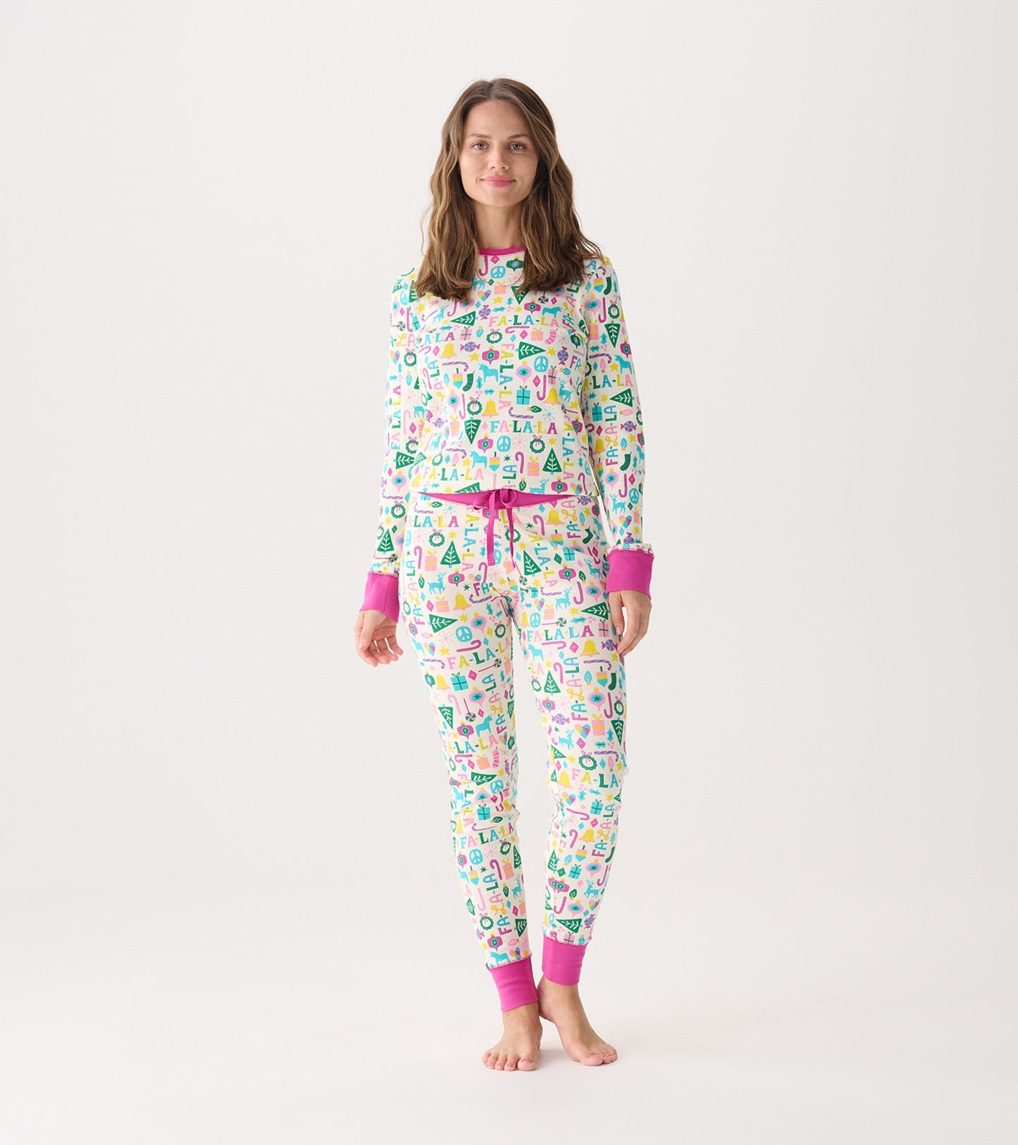 Women's pink pyjama set featuring a colorful pattern with festive motifs, long sleeves, and elastic waistband pants.