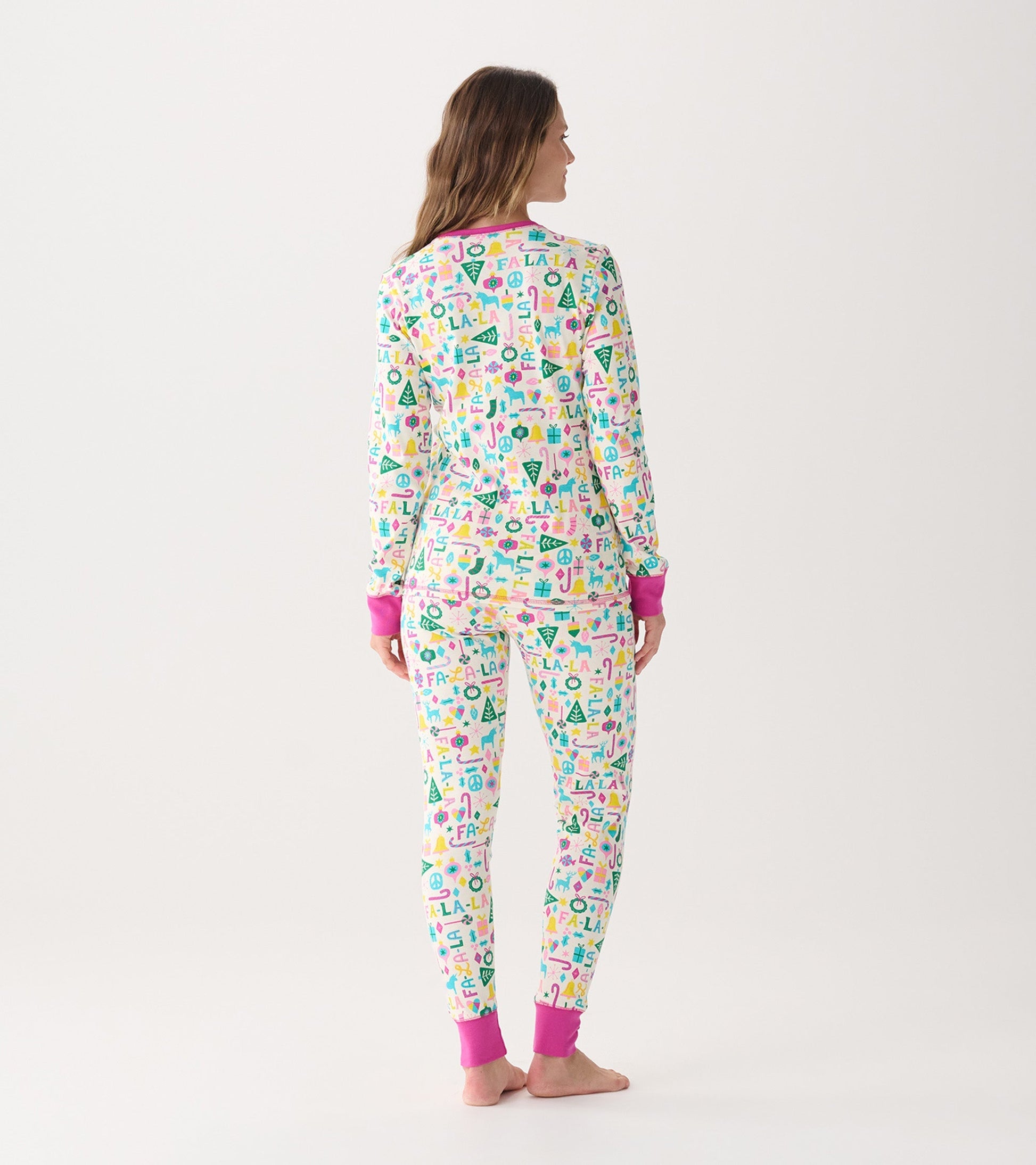 Women's pink pyjama set featuring a colorful festive pattern, with long sleeves and cuffs in a contrasting pink.