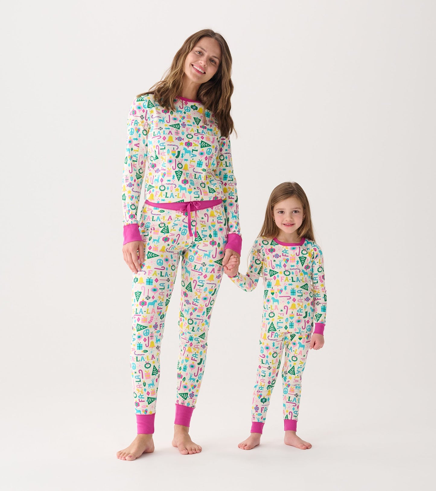 Matching women's and girl's pink pajama sets with colorful patterns, featuring long sleeves and elastic cuffs.