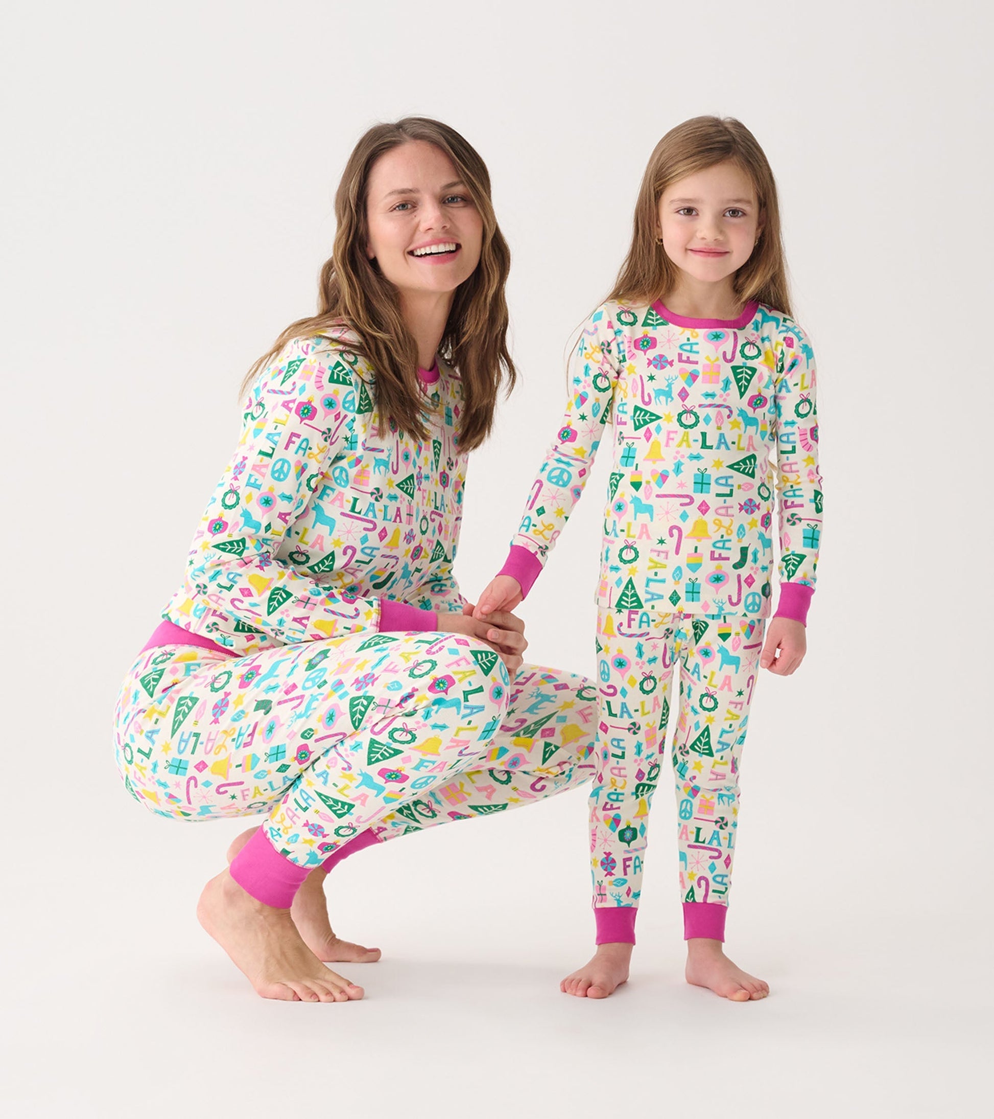 Matching pink and white pajama set for women and child, featuring playful patterns and contrasting cuffs.