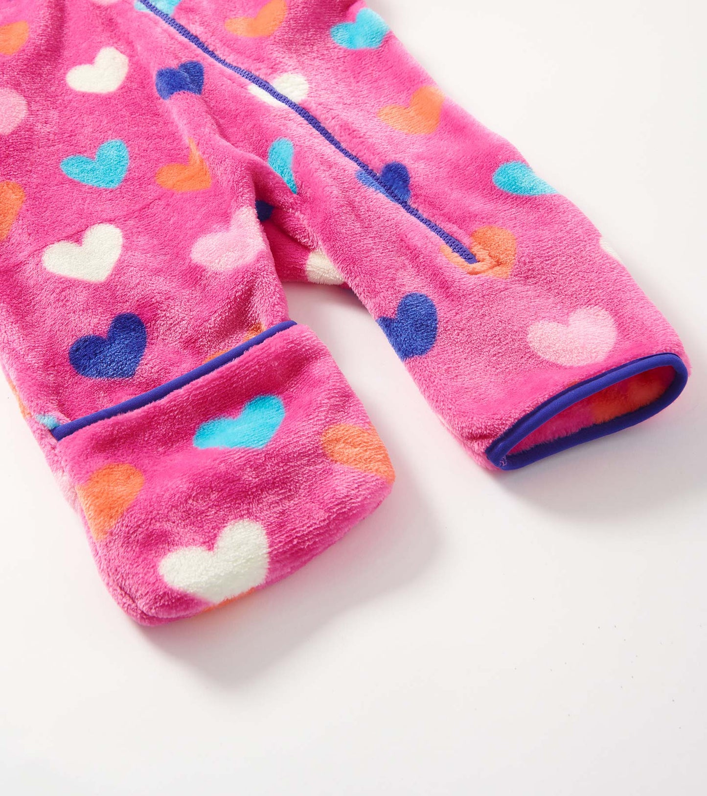 Pink fleece suit with multicolored heart patterns and blue trim, designed for baby girls.