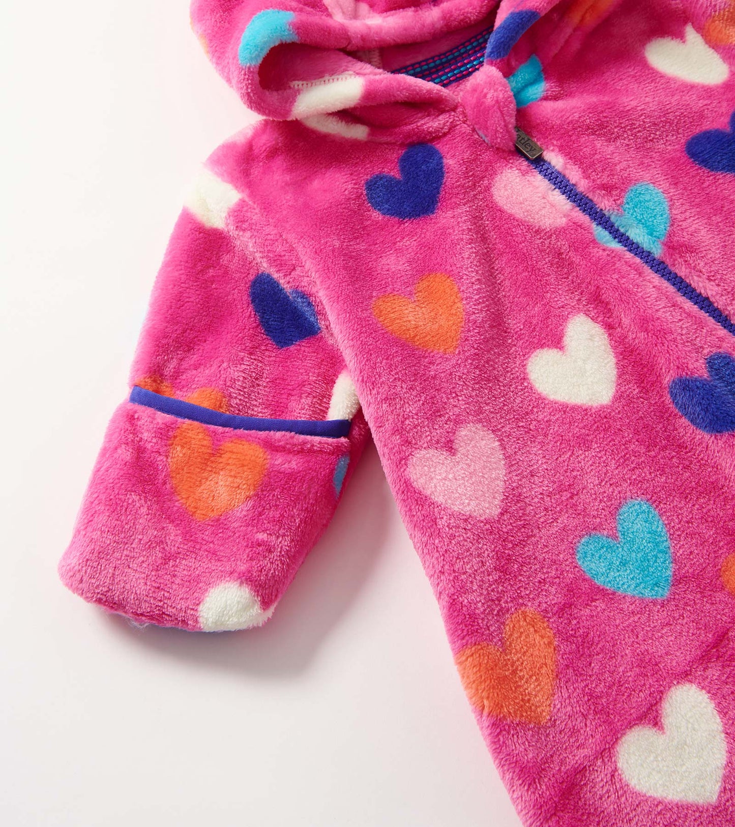 Pink fleece suit with colorful heart patterns, featuring a hood and long sleeves.