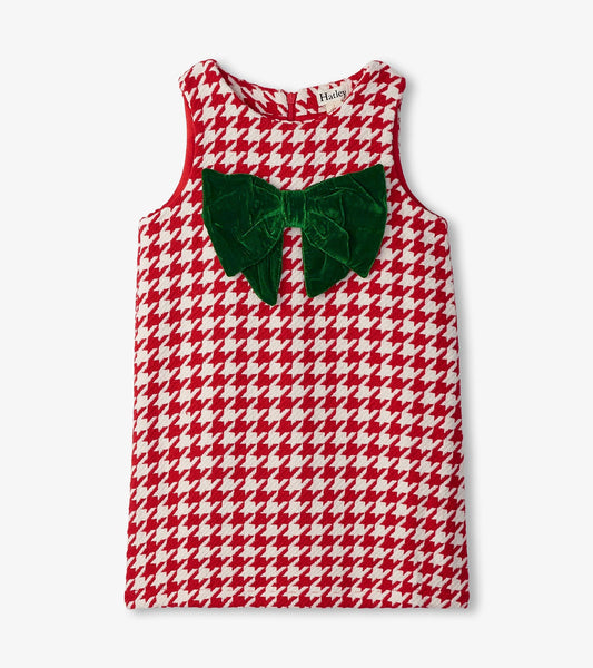 Red and white houndstooth dress with a large green velvet bow on the front, sleeveless design.