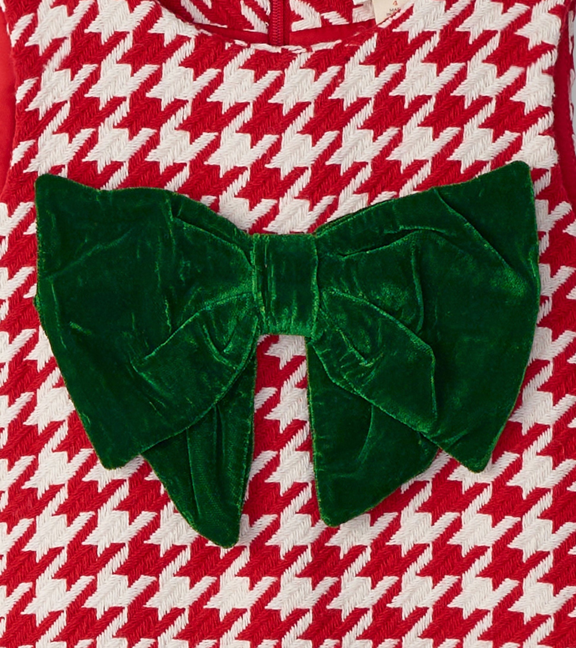 Red and white houndstooth dress featuring a large green velvet bow at the front.
