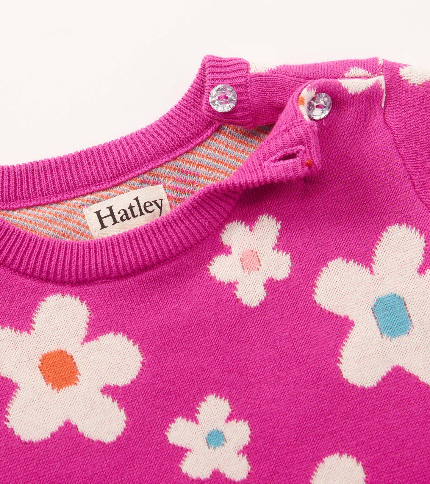 Pink sweater dress featuring white flowers with colorful centers, designed for baby and toddler girls.