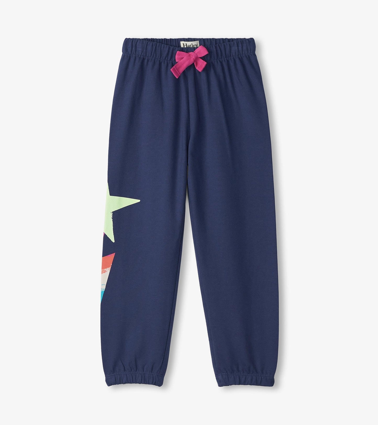 Navy baggy track pants with a colorful star graphic and a pink bow at the waist, featuring elastic cuffs.