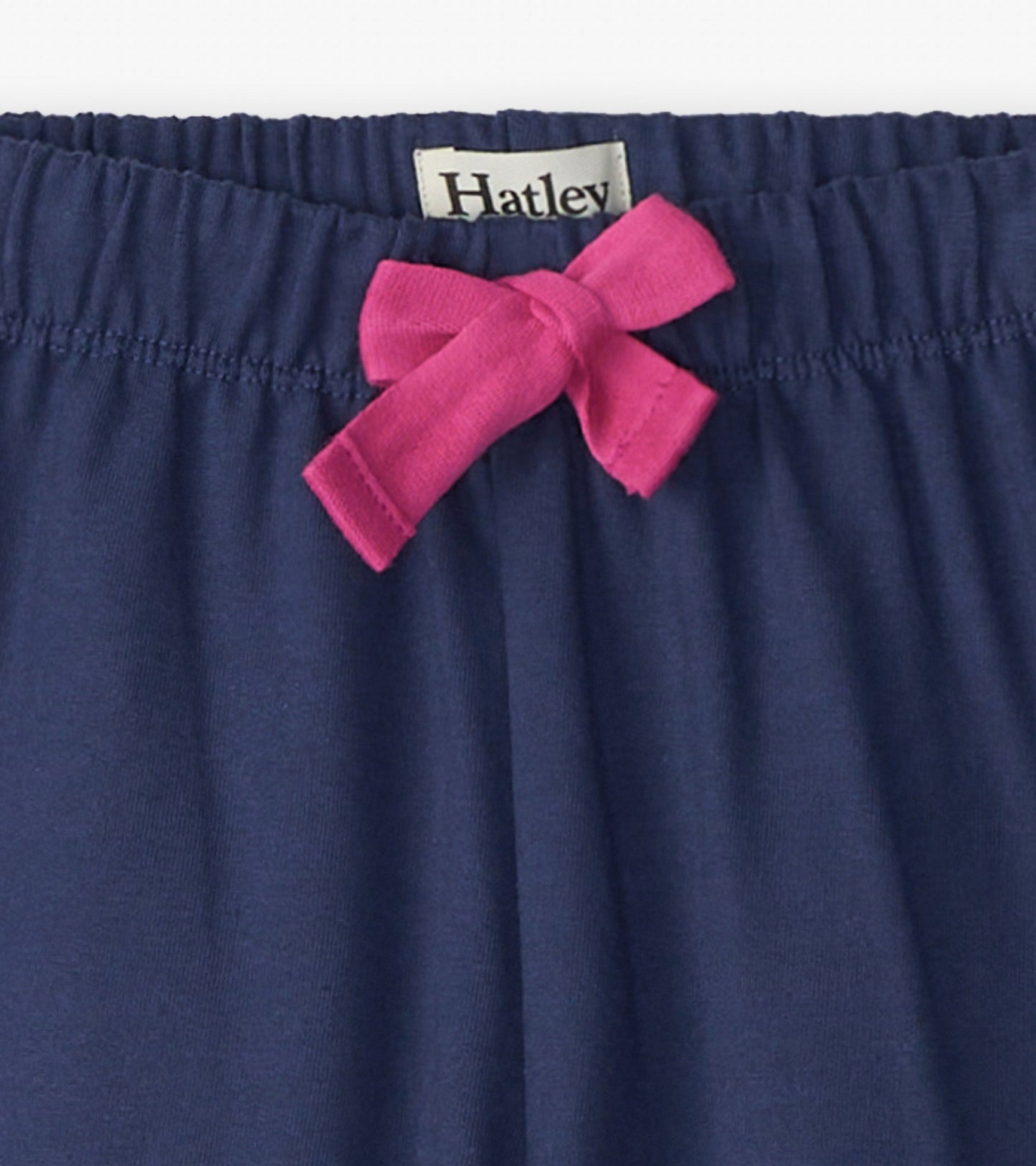 Navy baggy track pants with an elastic waistband and a pink bow detail at the front.