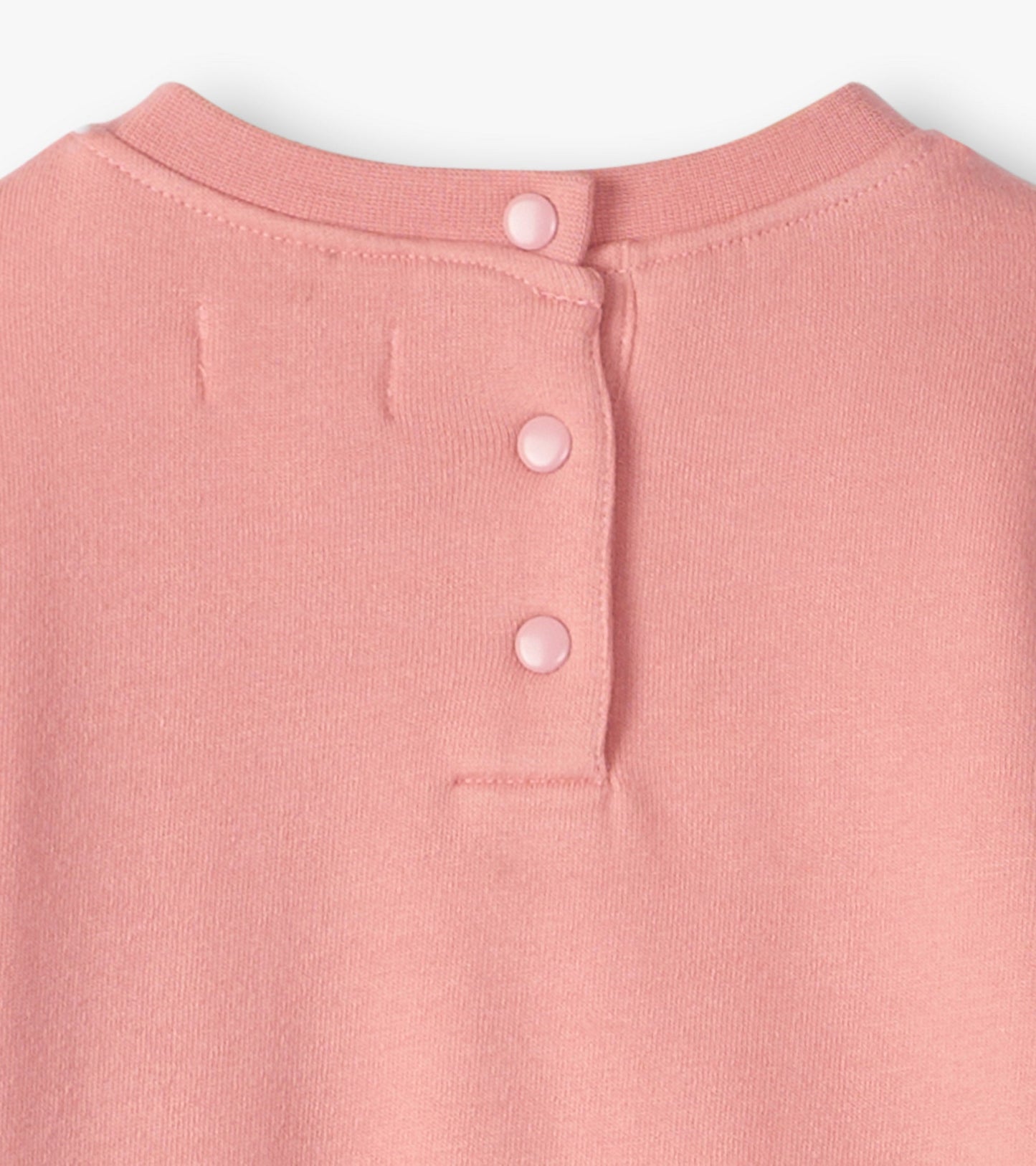 Light pink cozy dress with a rounded neckline and three button closure at the back. Soft fabric suitable for baby and toddle…