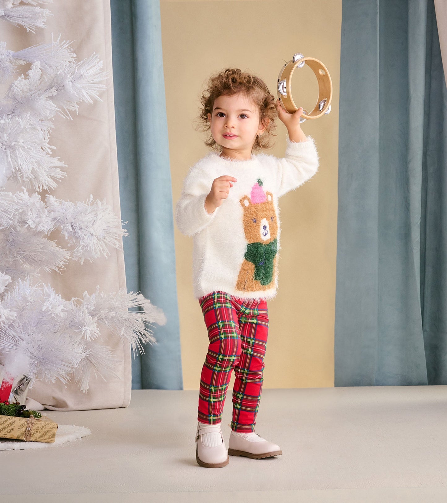 Red plaid leggings for babies and toddlers, featuring a snug fit and soft fabric, styled with a cozy white sweater.
