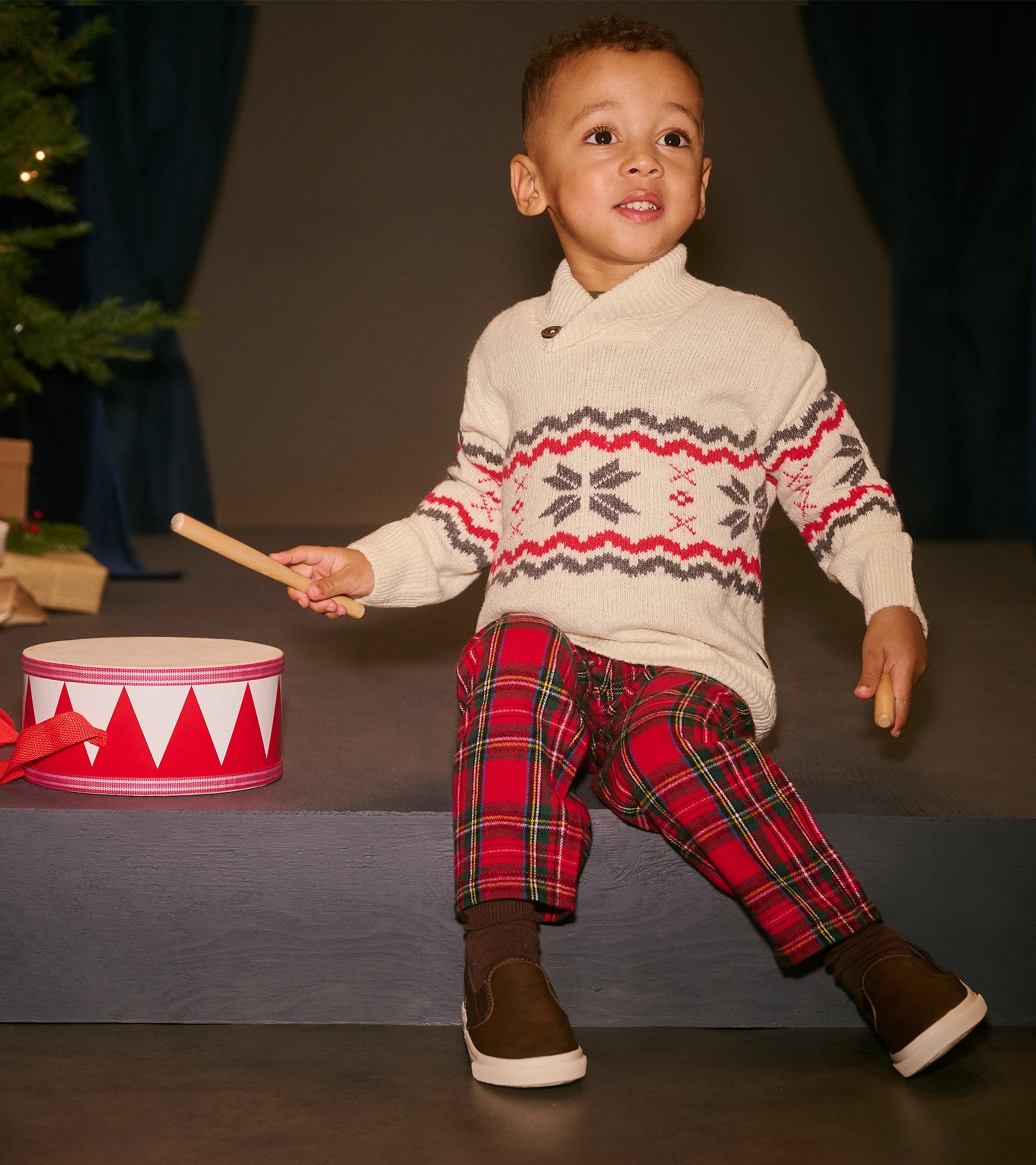 Red plaid straight leg pants for babies and toddlers, styled with a cozy sweater and brown shoes.