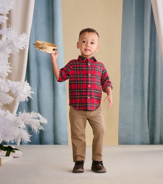 Red plaid button-down shirt for toddlers, featuring short sleeves and a relaxed fit, worn by a child holding a tambourine.