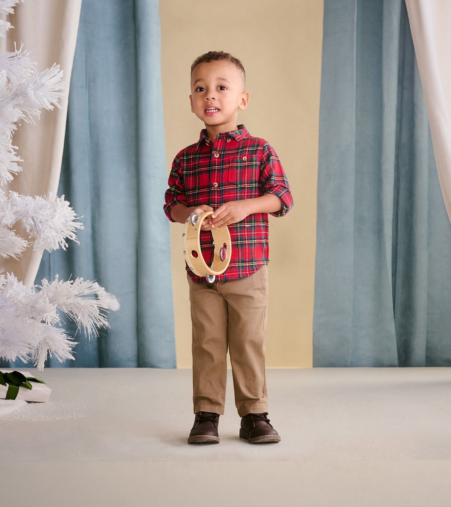 Red plaid button-down shirt for toddlers, featuring a collar and button closure, paired with beige pants.
