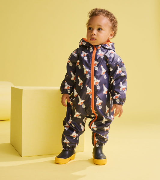 Navy rain suit for baby boys featuring colorful space shuttle prints, with an orange zipper and hood, paired with yellow boo…