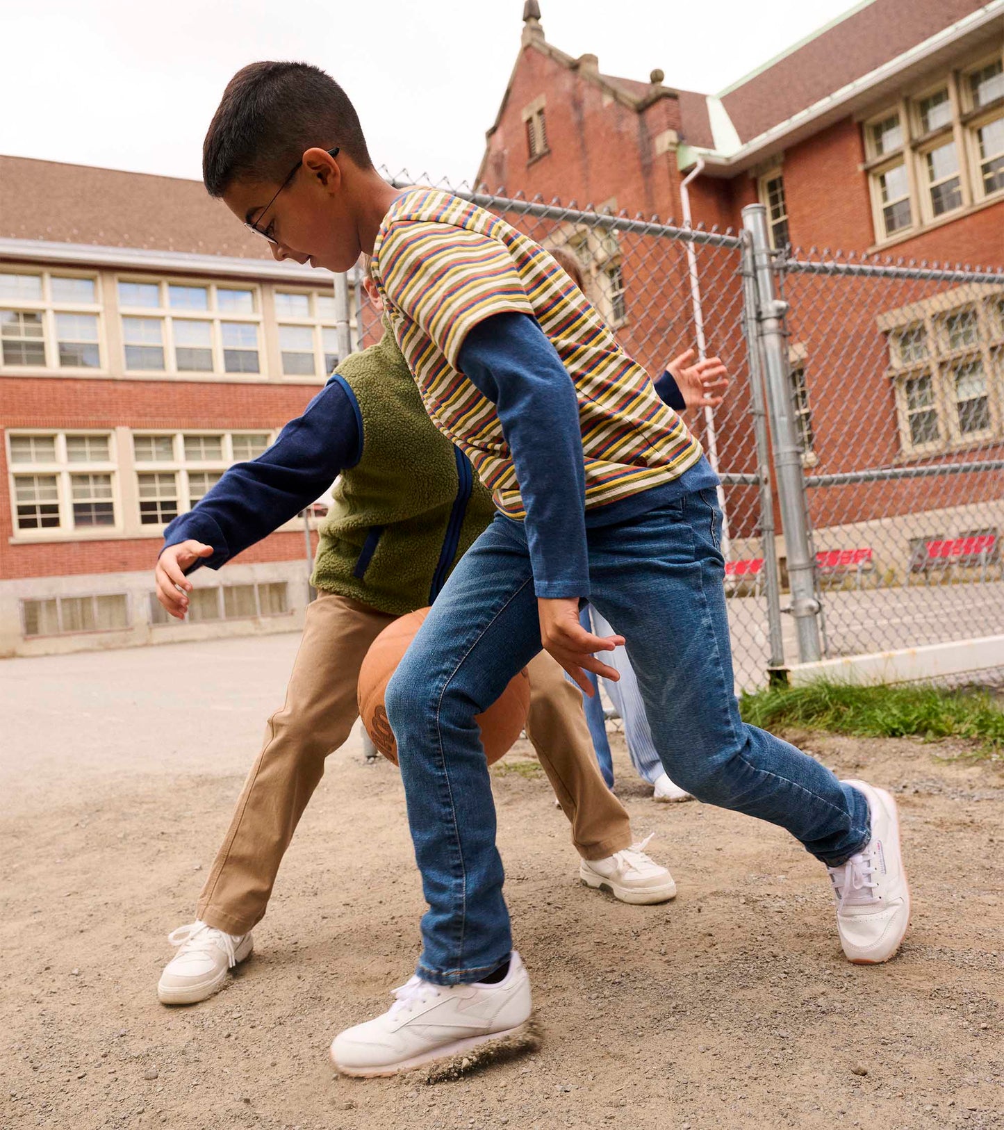 Boys' long sleeve T-shirt featuring autumn stripes, paired with denim jeans, worn during outdoor play.