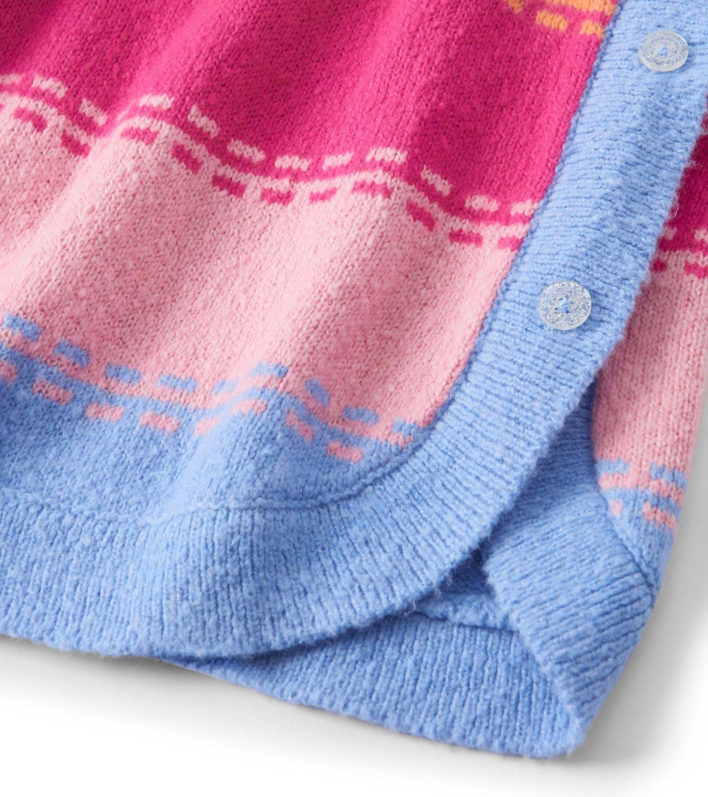 Chunky sweater tunic featuring a pink and blue color scheme with a bold stitch pattern and button detail.