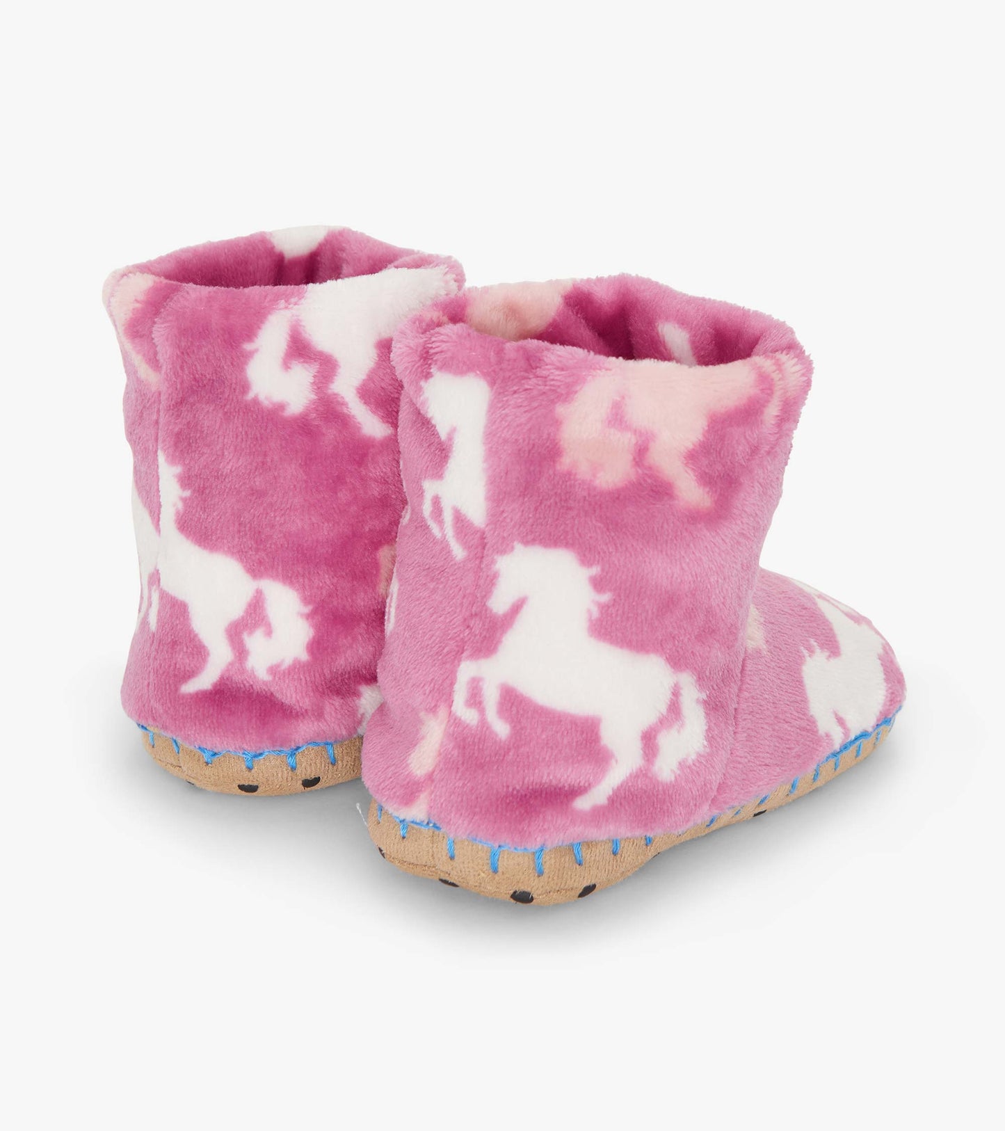 Pink fuzzy fleece slippers featuring white unicorn patterns and a soft sole. Ideal for cozy indoor wear.