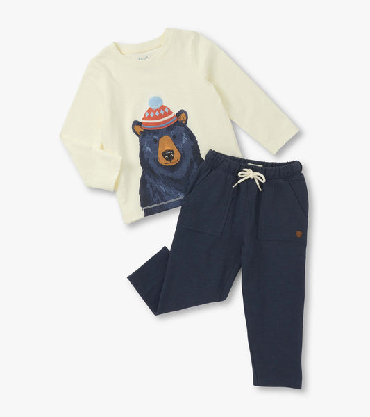 Cream long-sleeve shirt with bear graphic and navy lounge pants with pockets and drawstring waist.
