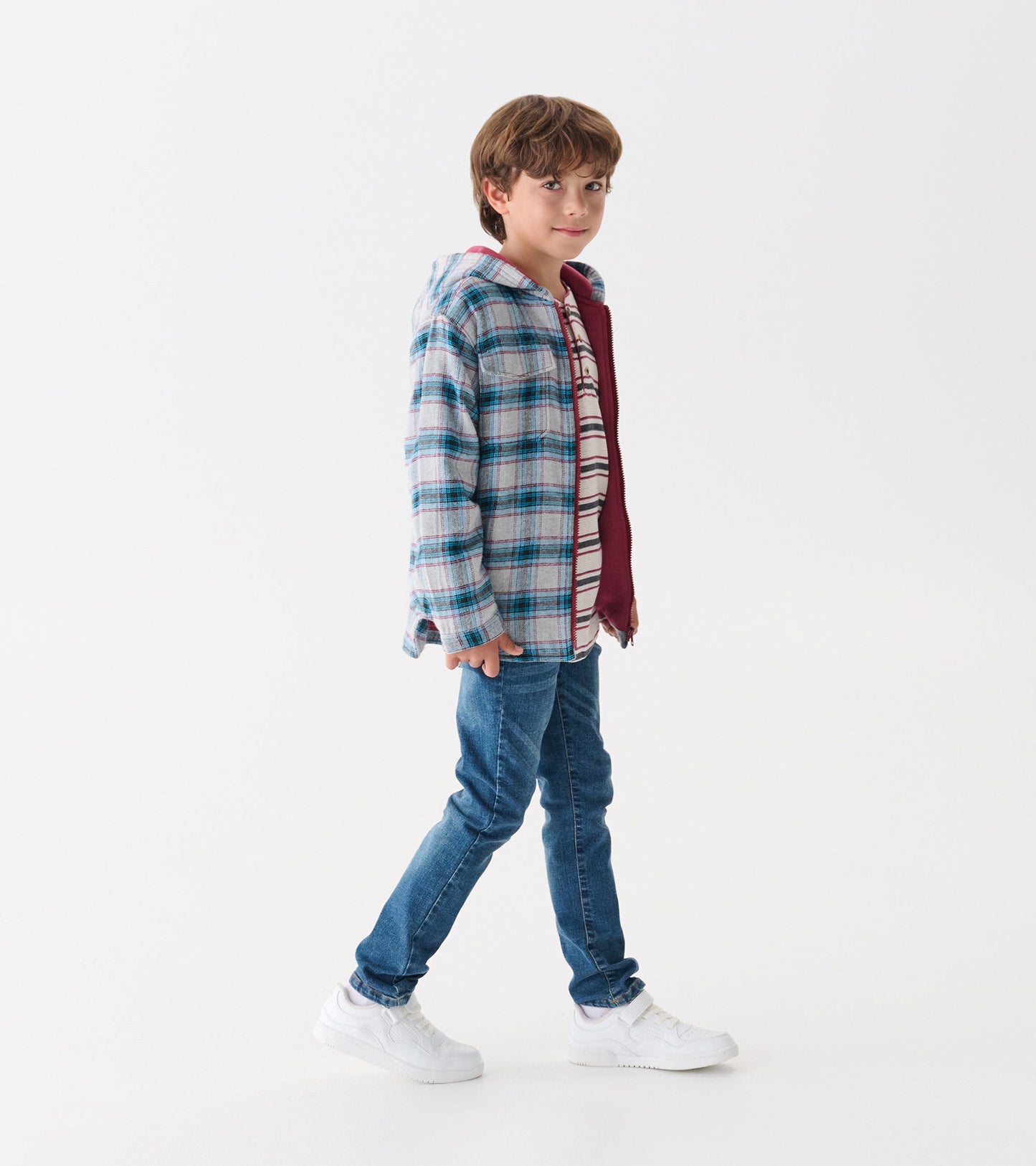 Charcoal and maroon plaid hooded jacket on a boy, paired with a striped shirt and jeans, standing against a white background.