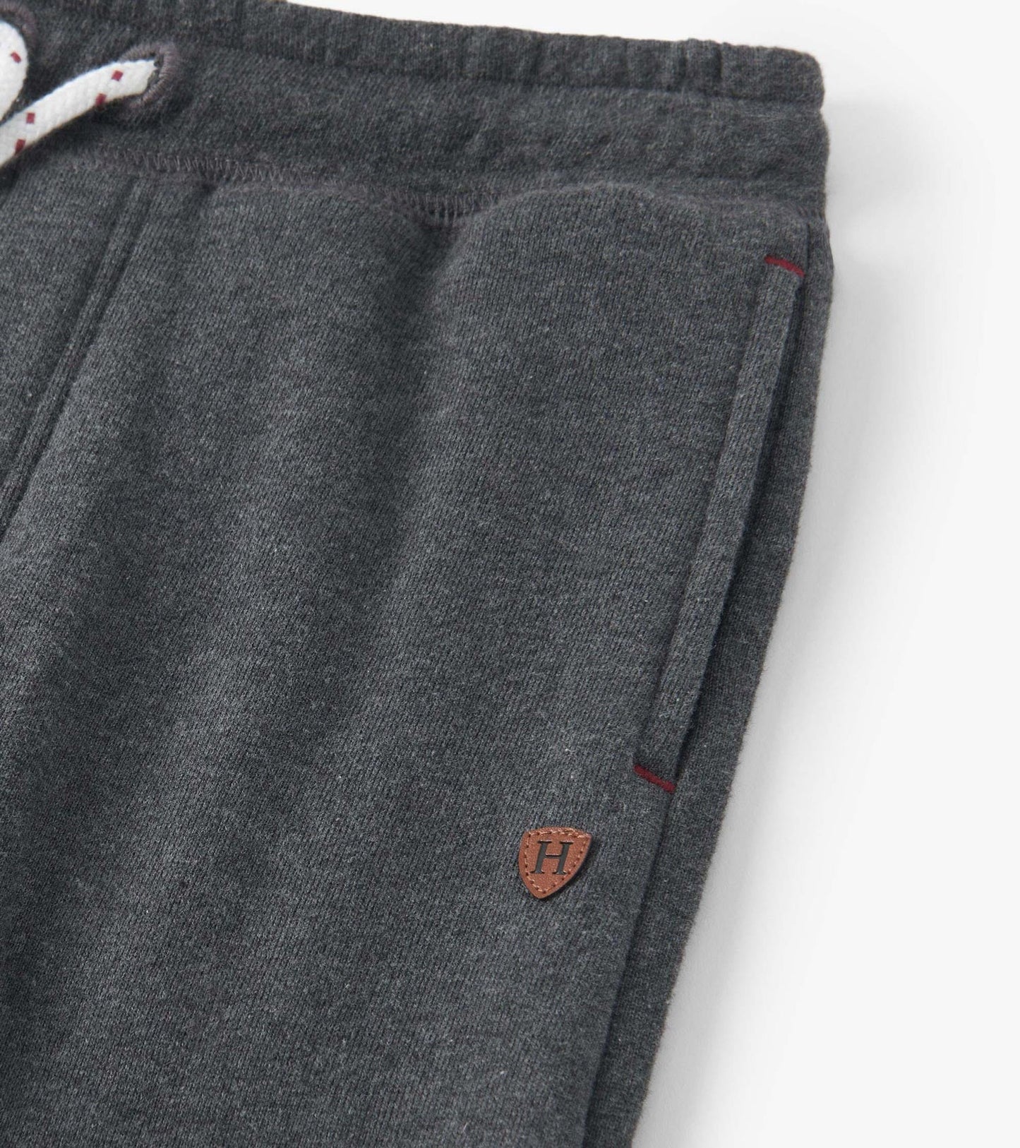 Charcoal melange joggers with a drawstring waist, side pockets, and a small logo patch. Soft fabric for comfort.