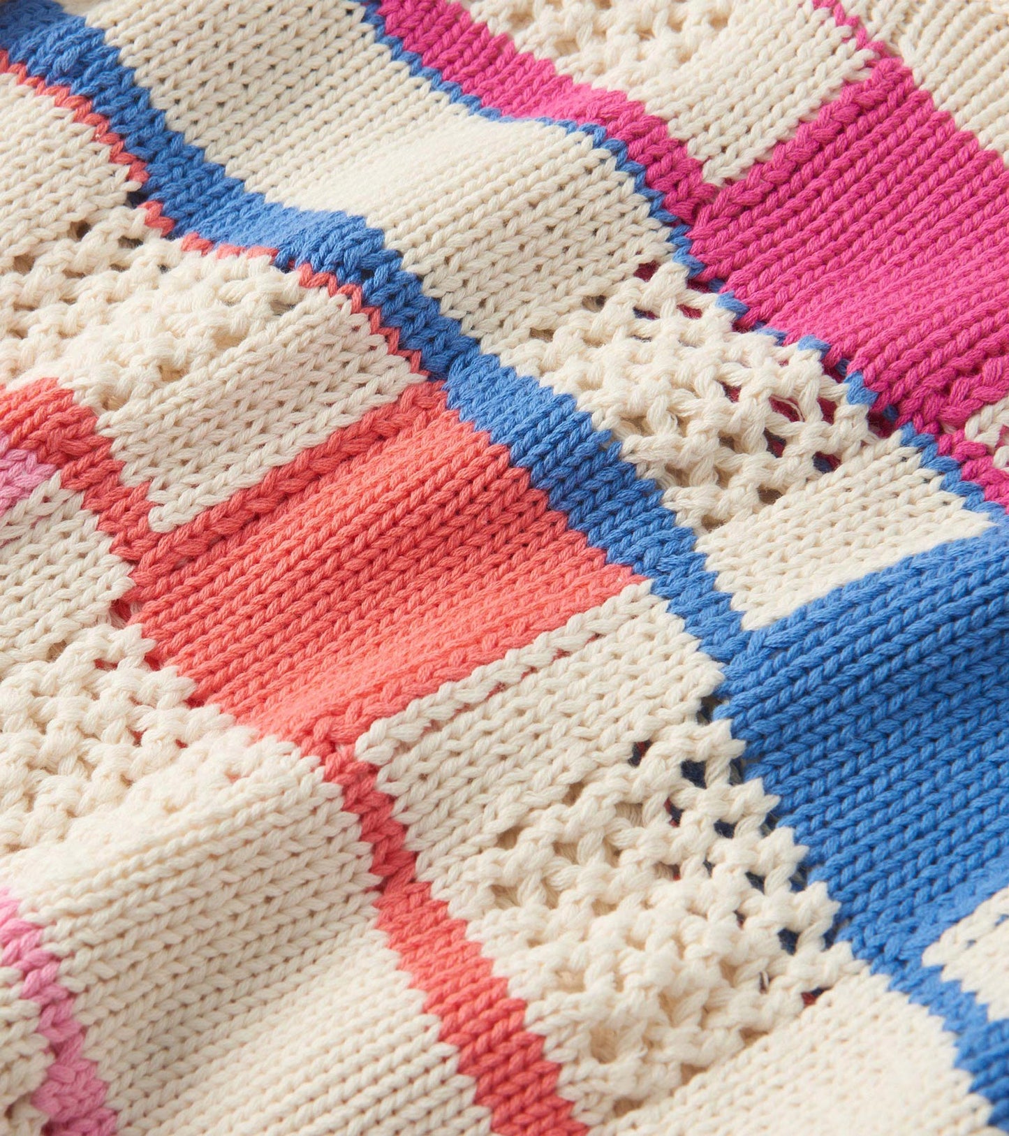 Knit sweater featuring a mix of colorful blocks in pink, blue, coral, and cream, with a textured pattern.