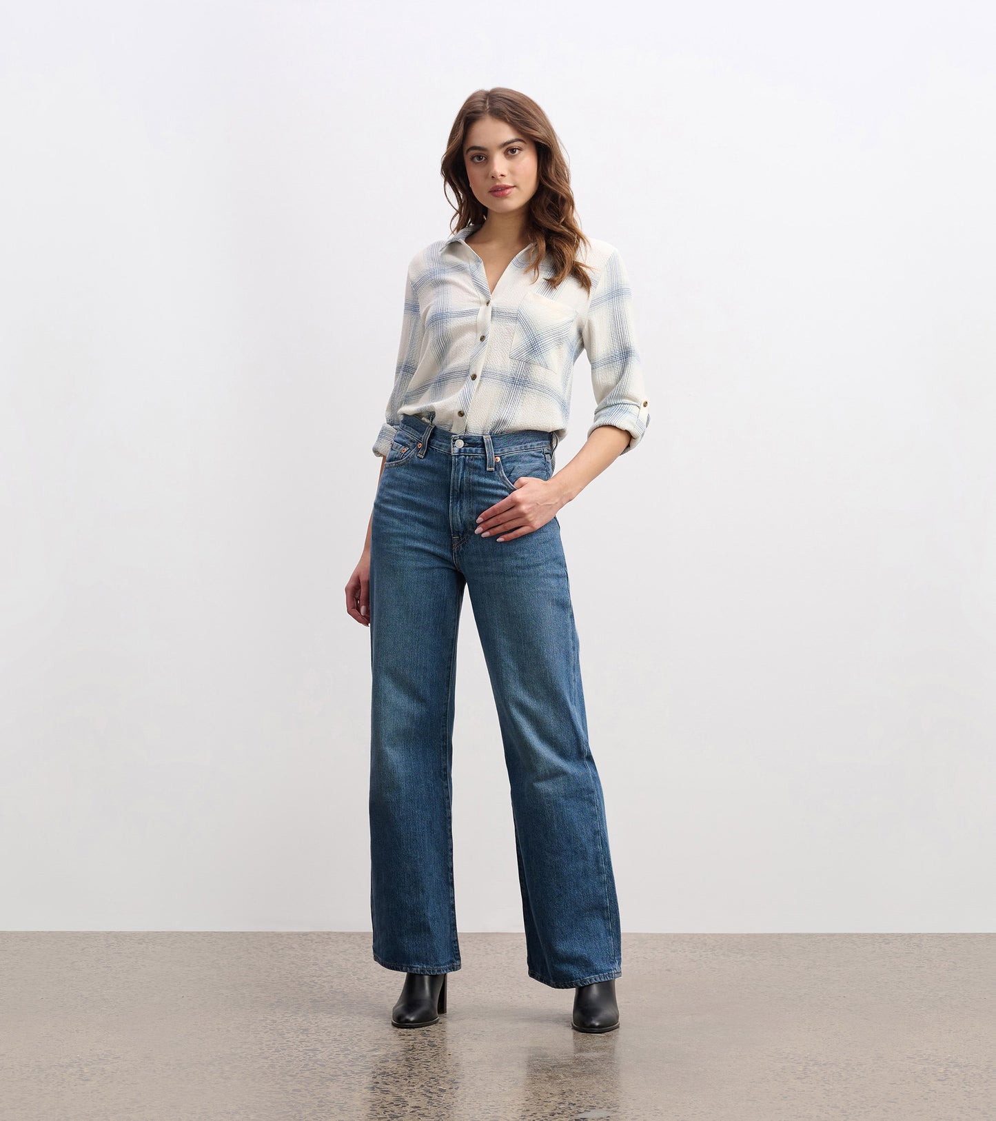 Turquoise plaid button-down shirt with a relaxed fit, paired with high-waisted jeans and ankle boots.