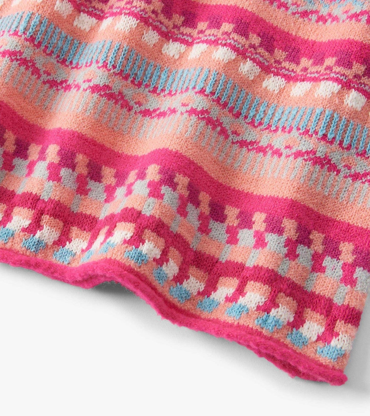 Knit sweater dress featuring sunset stripes in pink, peach, and blue with a cozy, textured pattern.