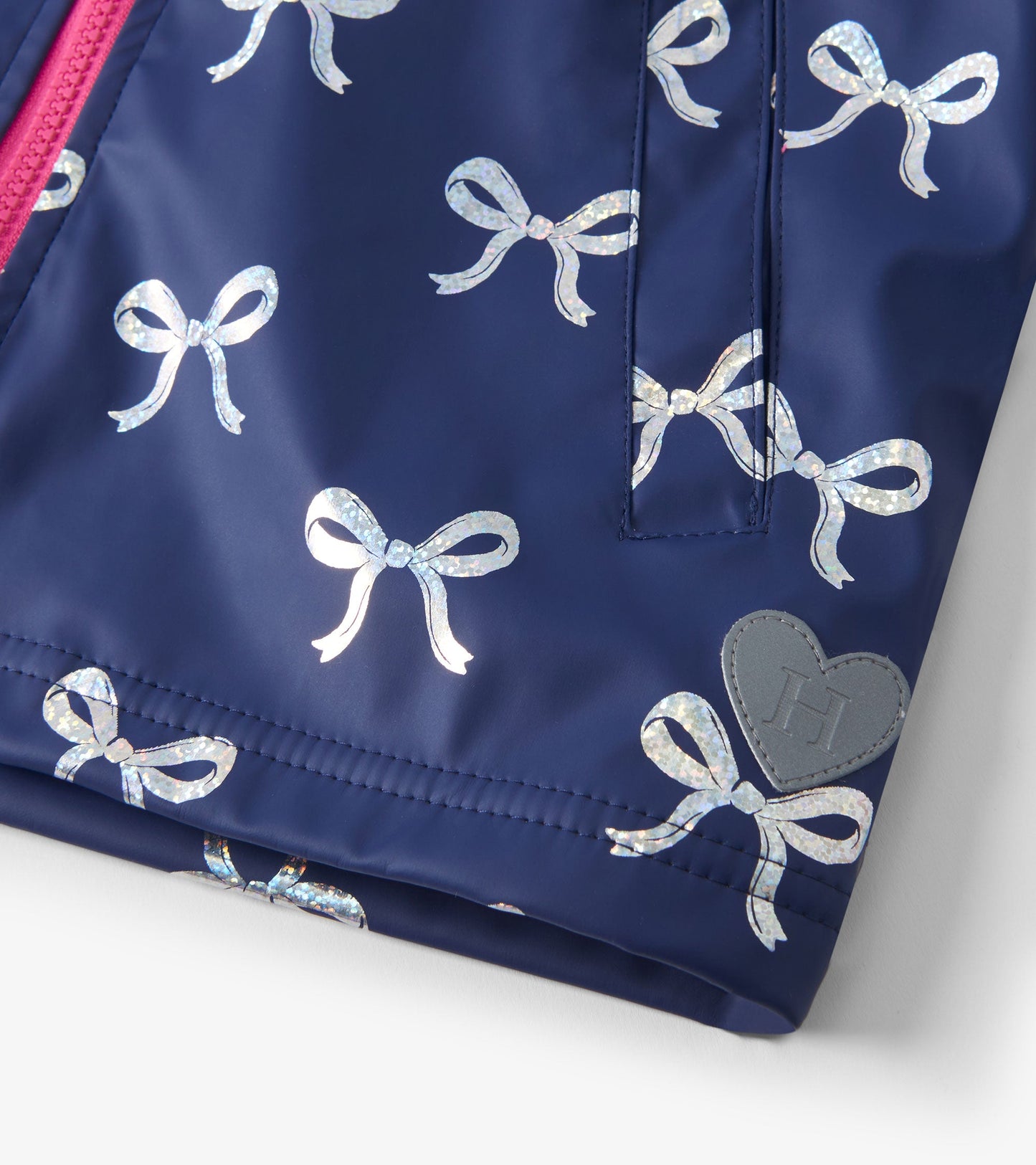 Navy raincoat featuring shiny silver ribbon patterns and a pink zipper, designed for girls.