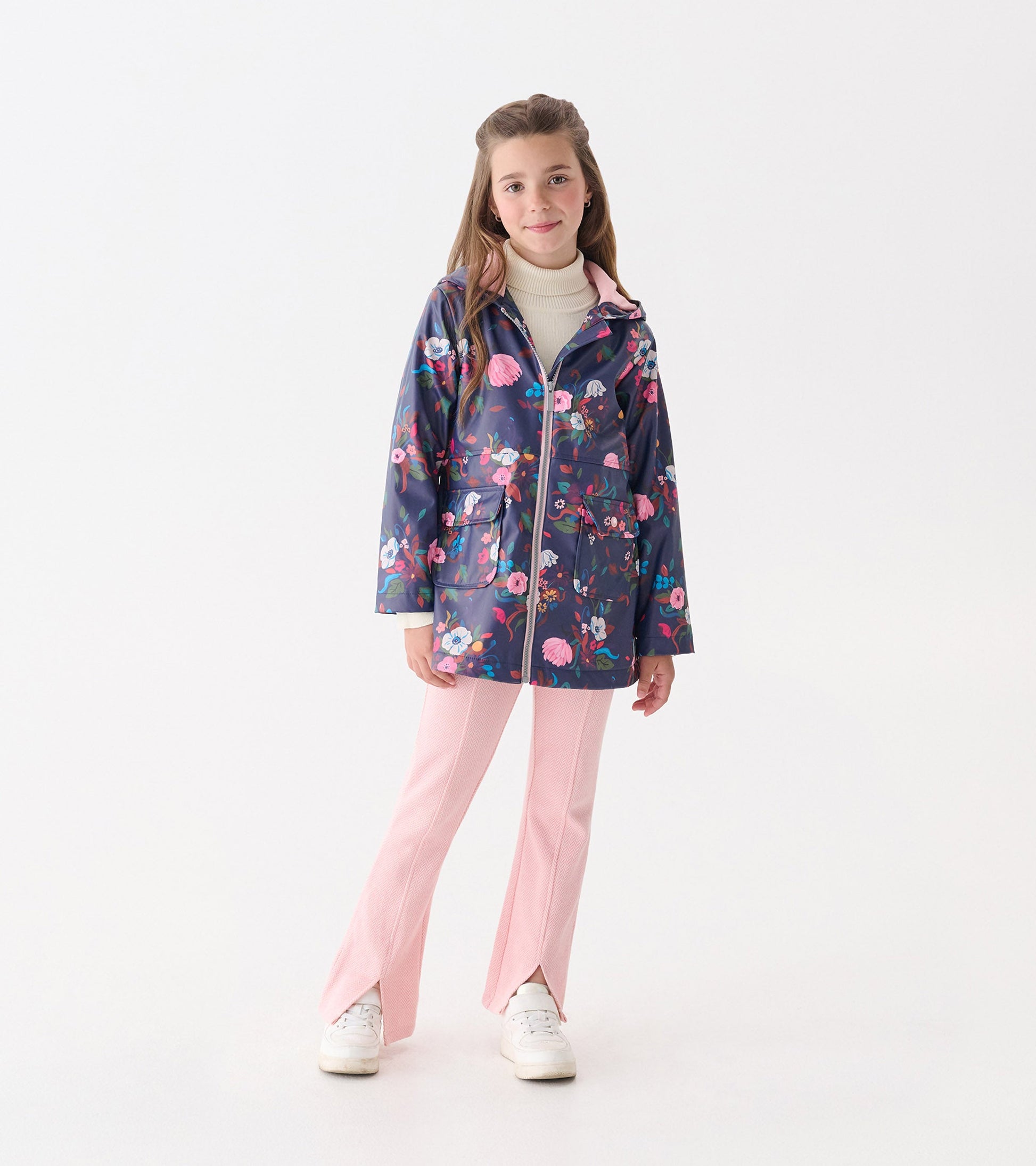 Navy floral zip-up raincoat with a hood, featuring pink accents and two front pockets, worn over pink pants.