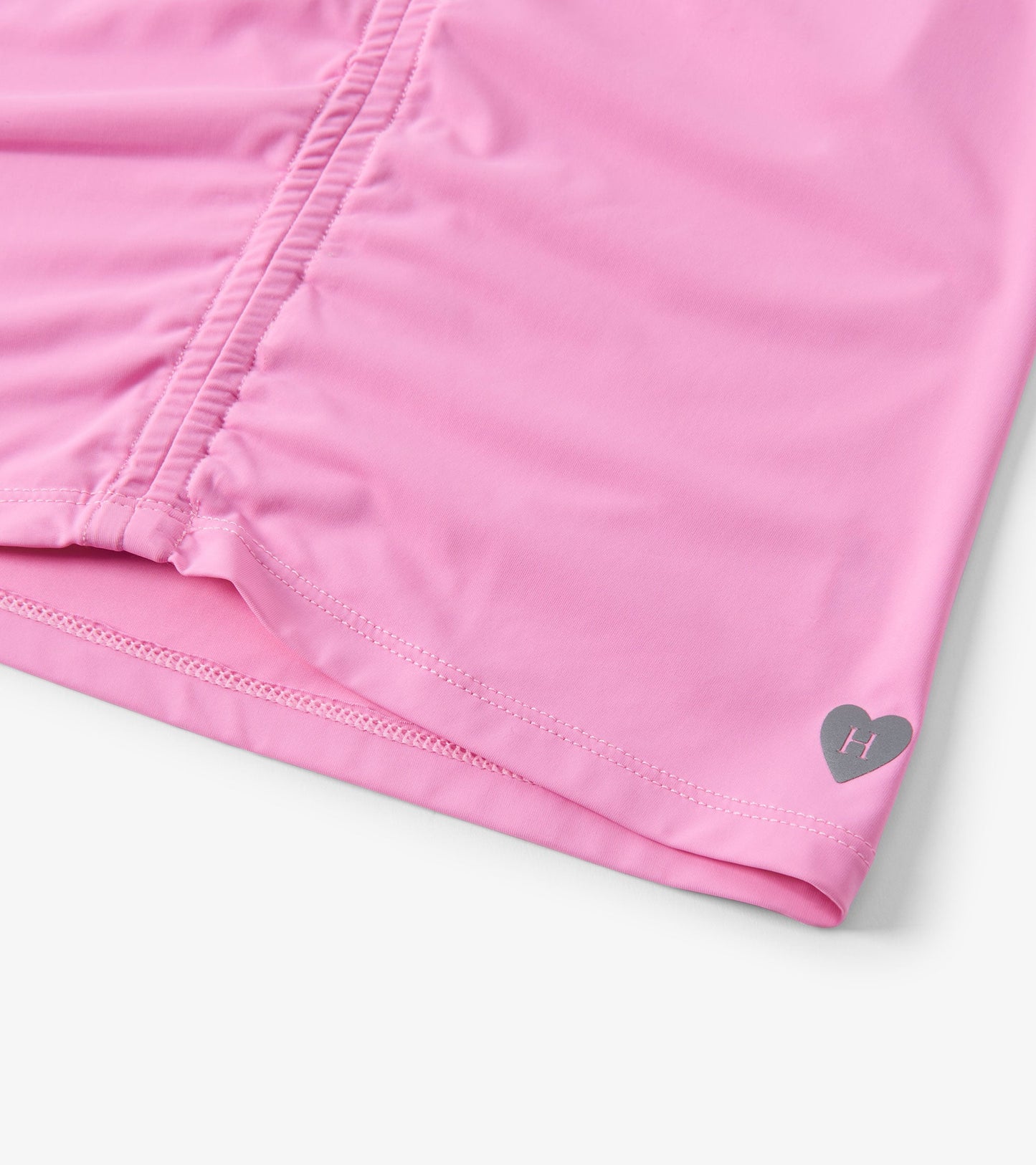 Fuchsia pink gathered front top with a heart logo, made from soft material, suitable for girls.