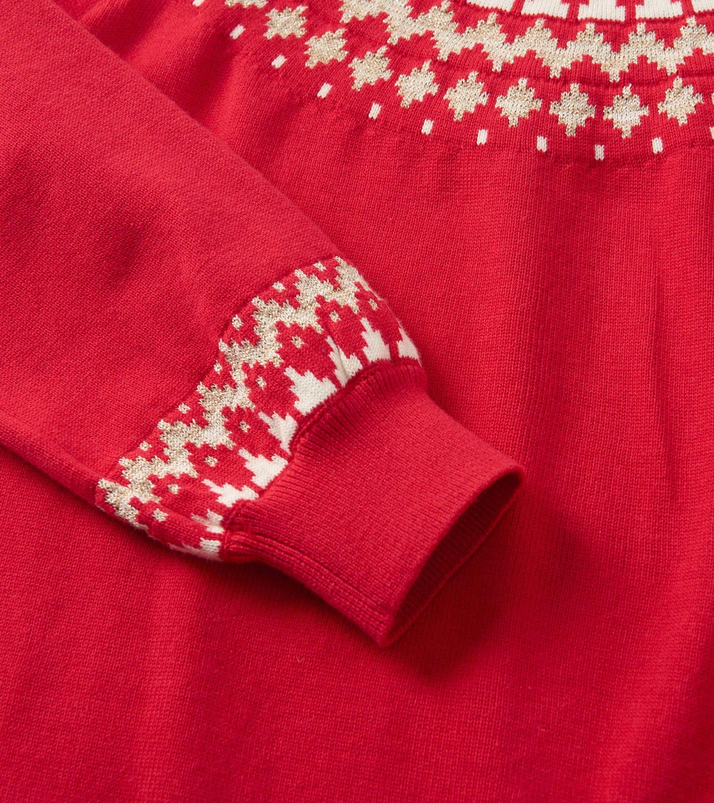 Red sweater dress featuring a Fair Isle pattern in gold and white at the neckline and cuffs, made from soft knit material.
