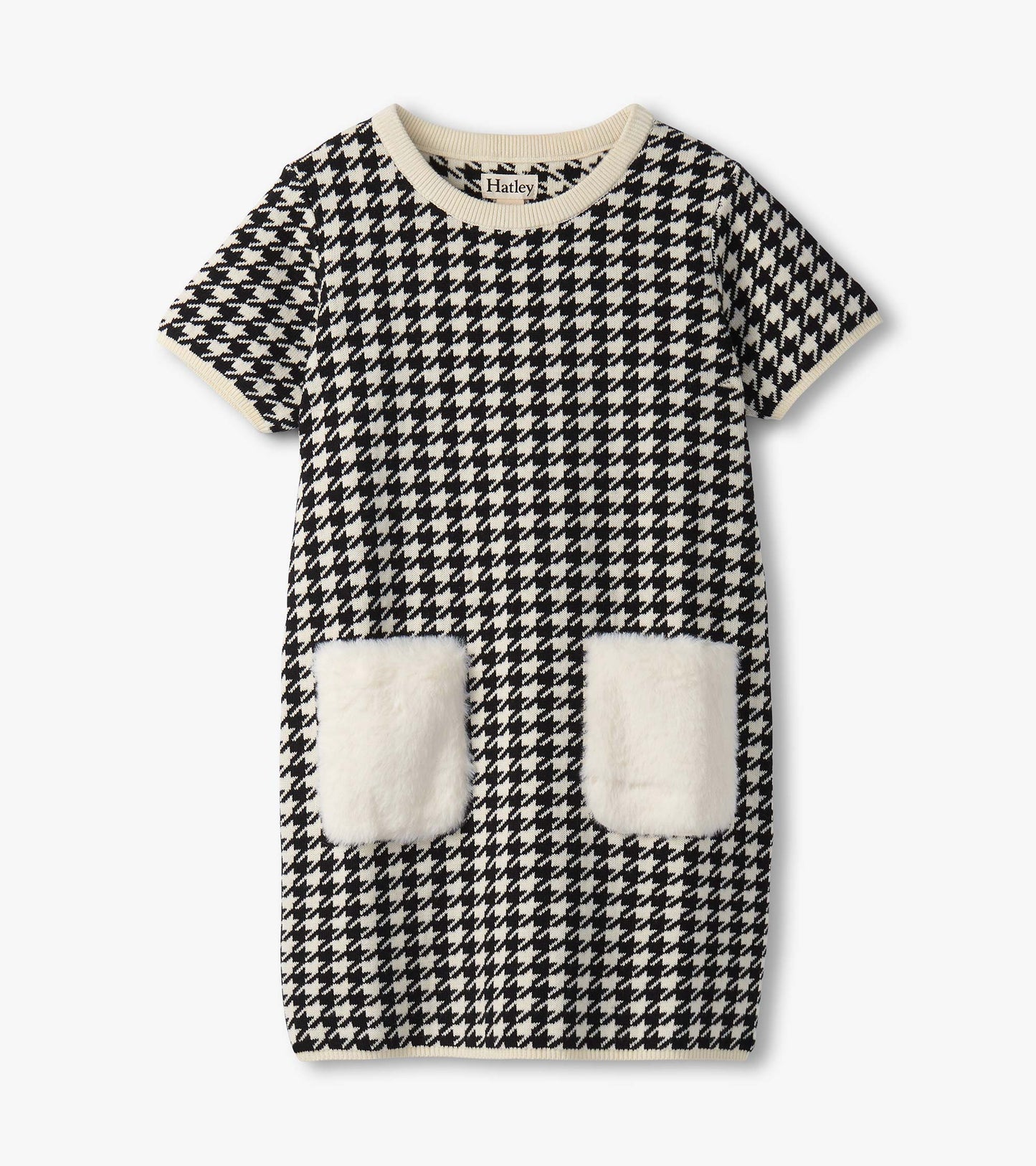 Black and white houndstooth sweater dress featuring faux fur pockets and a ribbed neckline. Short sleeves, casual style.