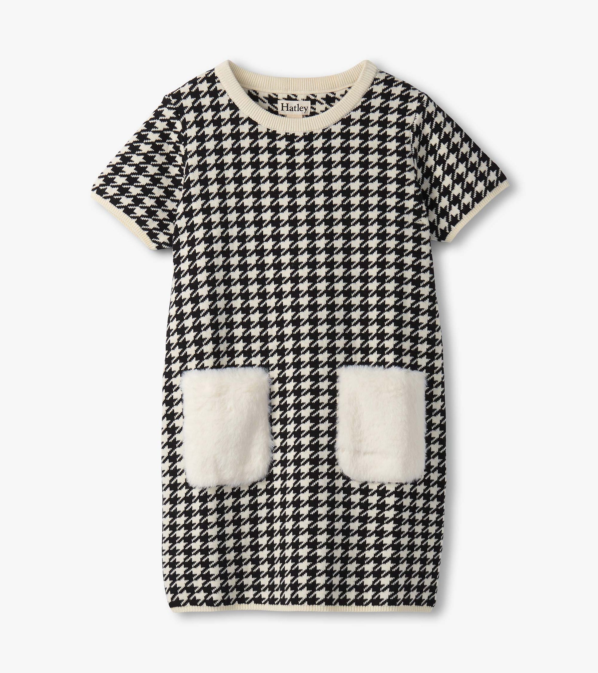 Black and white houndstooth sweater dress featuring faux fur pockets and a ribbed neckline. Short sleeves, casual style.