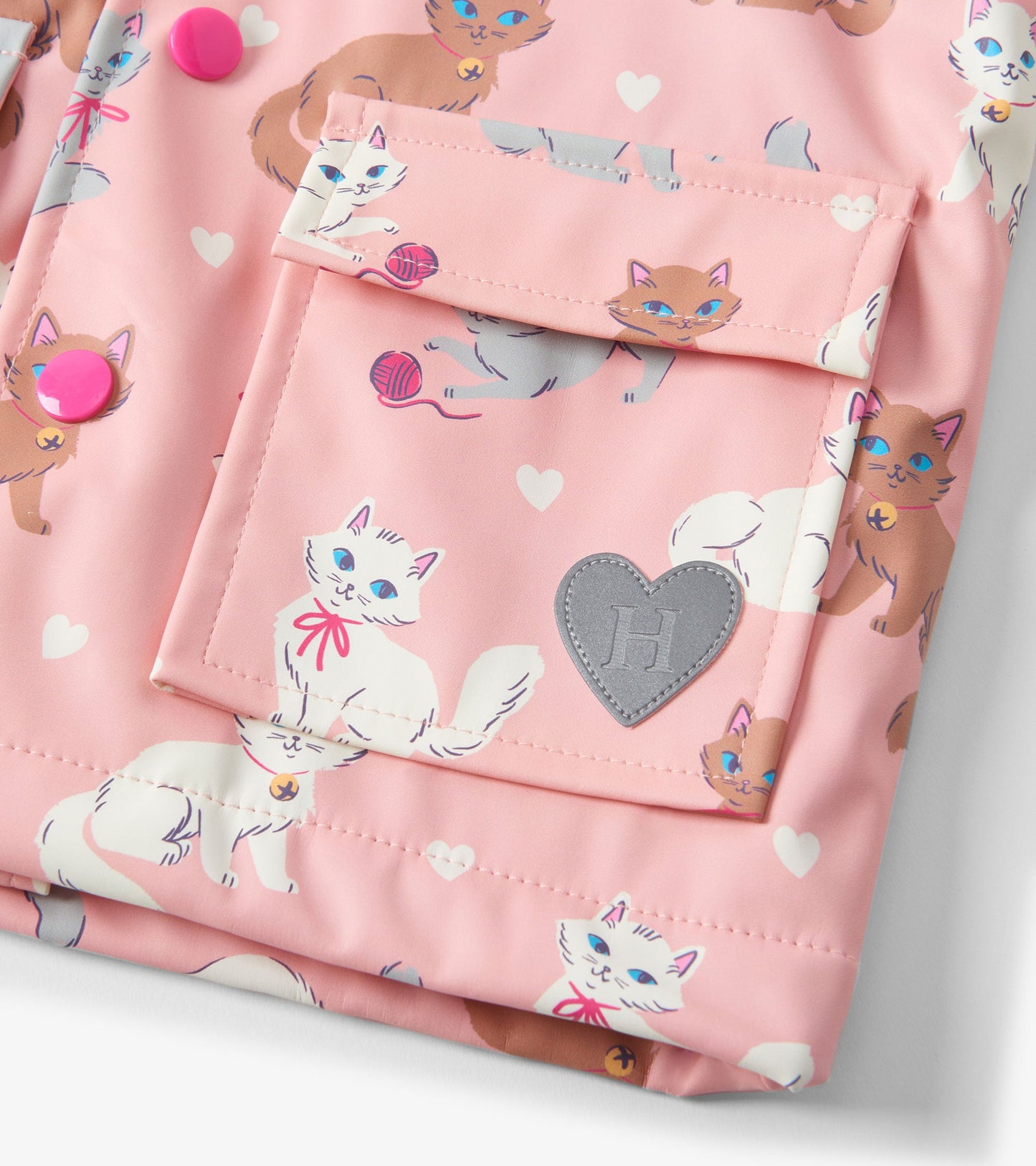 Pink raincoat featuring playful cat illustrations and heart patterns, with button closures and a front pocket.