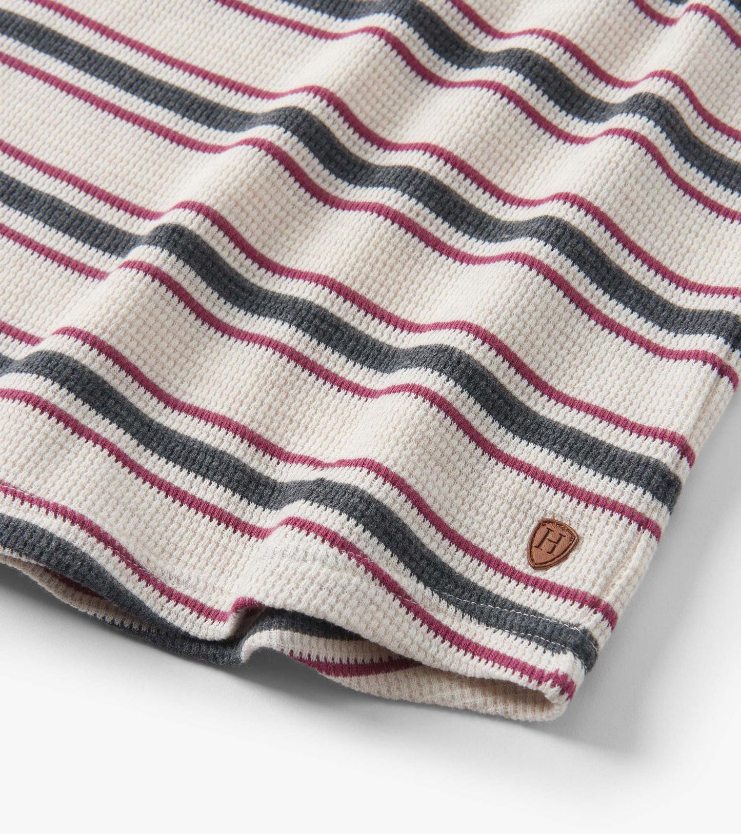 Oatmeal melange waffle henley featuring horizontal stripes in burgundy, navy, and cream with a small logo patch.