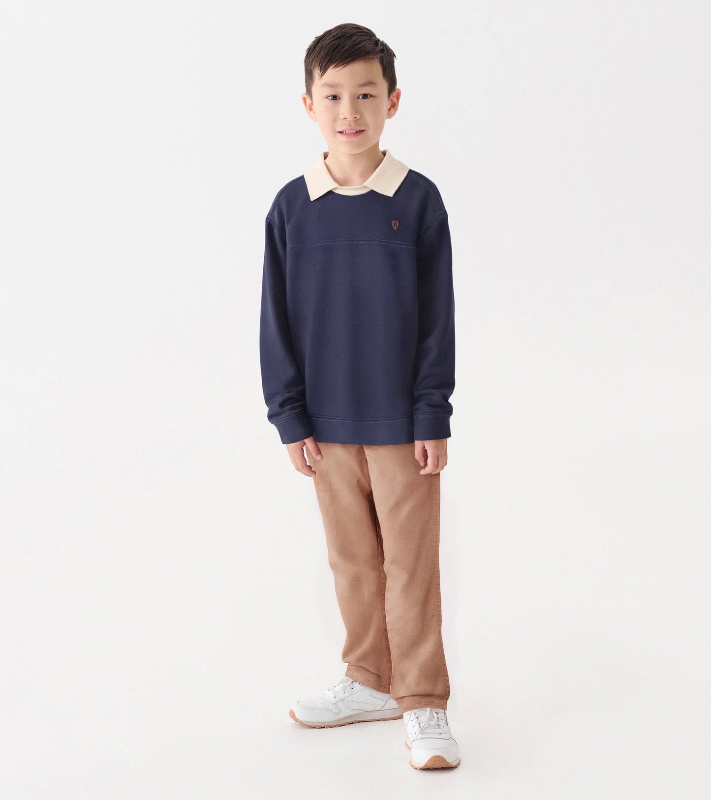 Patriot blue pullover with a cream collar, featuring a relaxed fit and long sleeves, worn by a boy standing casually.