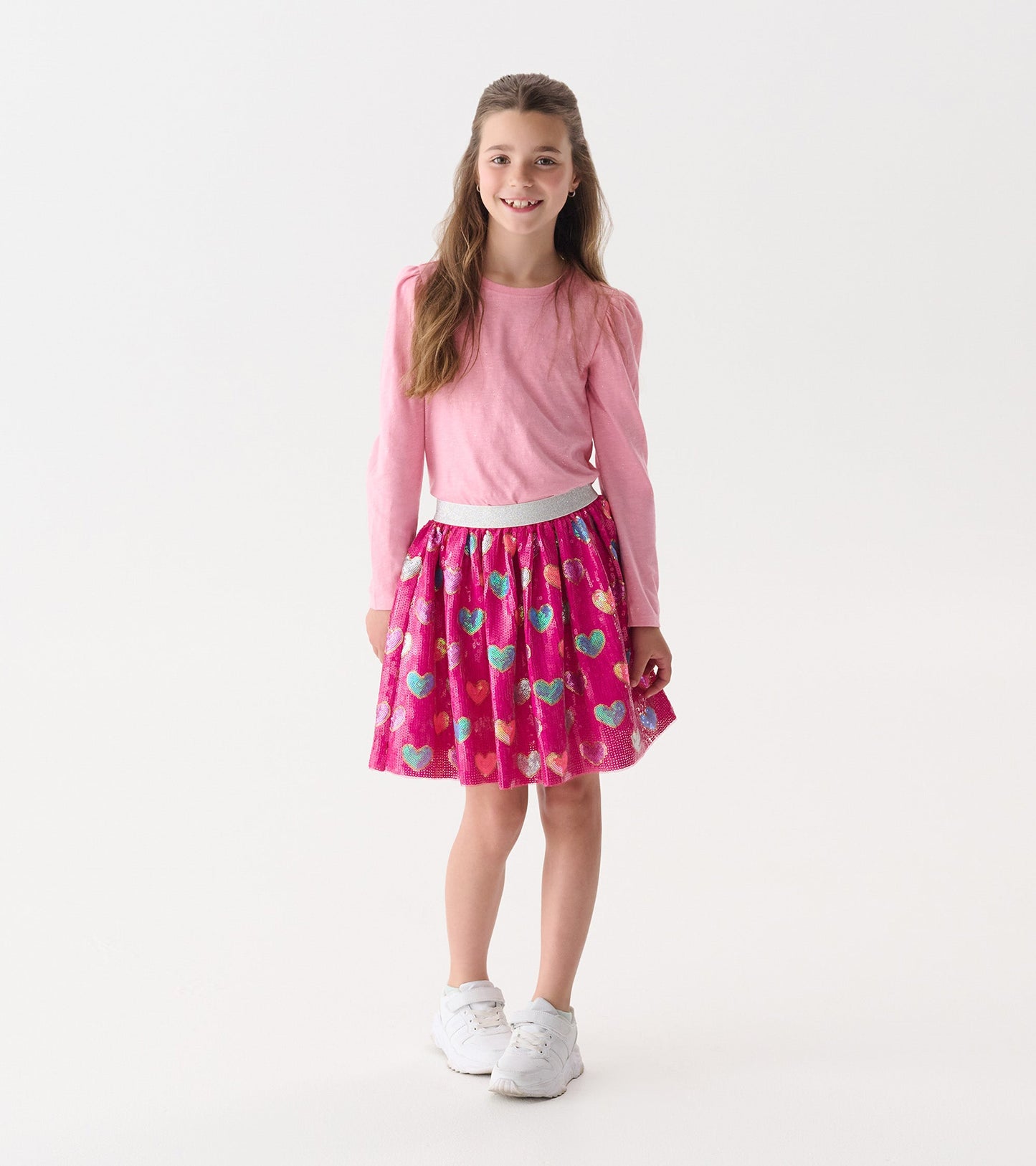 Pink sequin skirt featuring colorful heart patterns, with a gathered waist and a playful, flared shape.