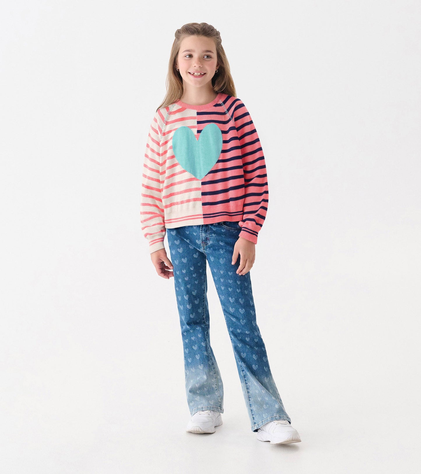 Striped sweater in pink and cream with a large turquoise heart, paired with heart-patterned jeans.