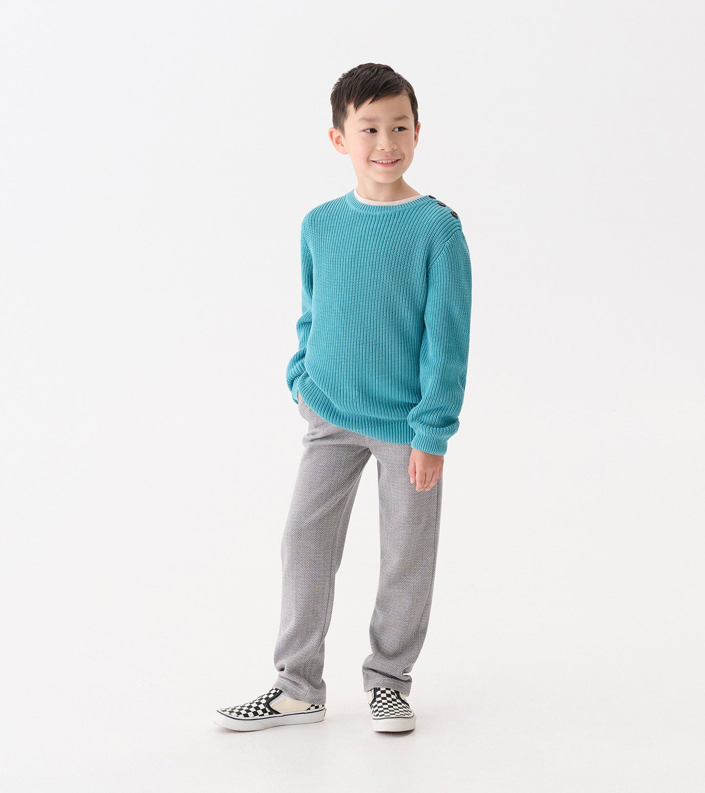 Teal button neck sweater with a textured knit, paired with gray pants and black and white checkered shoes.