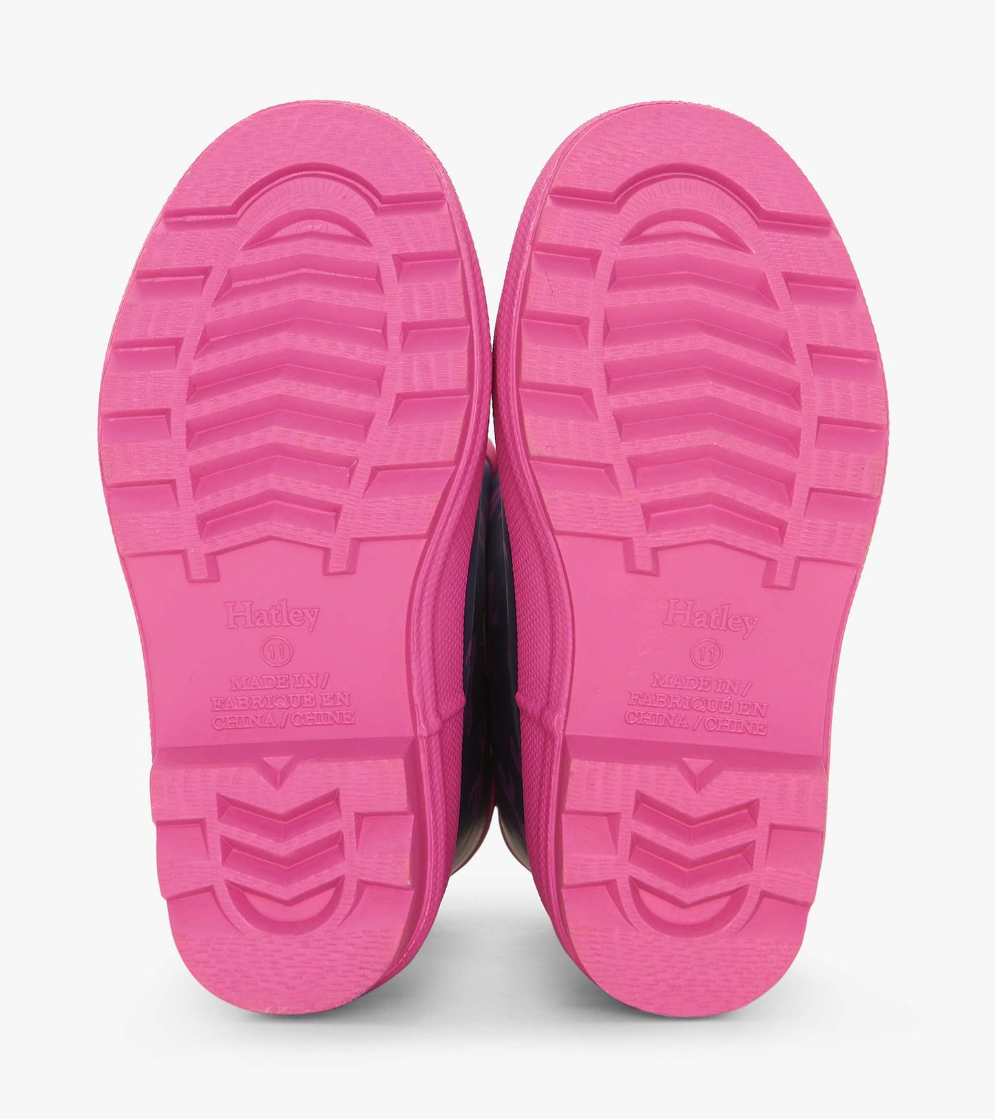 Pink rubber soles of wellies with textured grip pattern, designed for kids, showcasing durability and comfort.