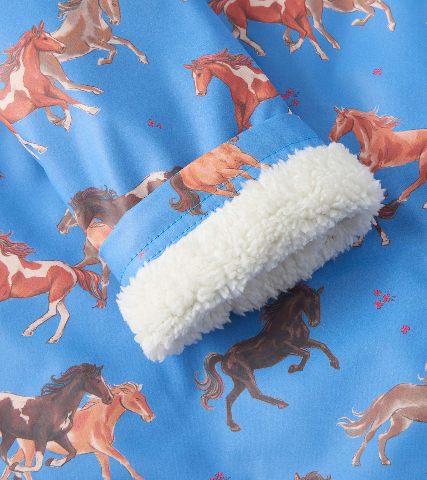 Blue raincoat featuring a playful horse print and a soft sherpa-lined collar.